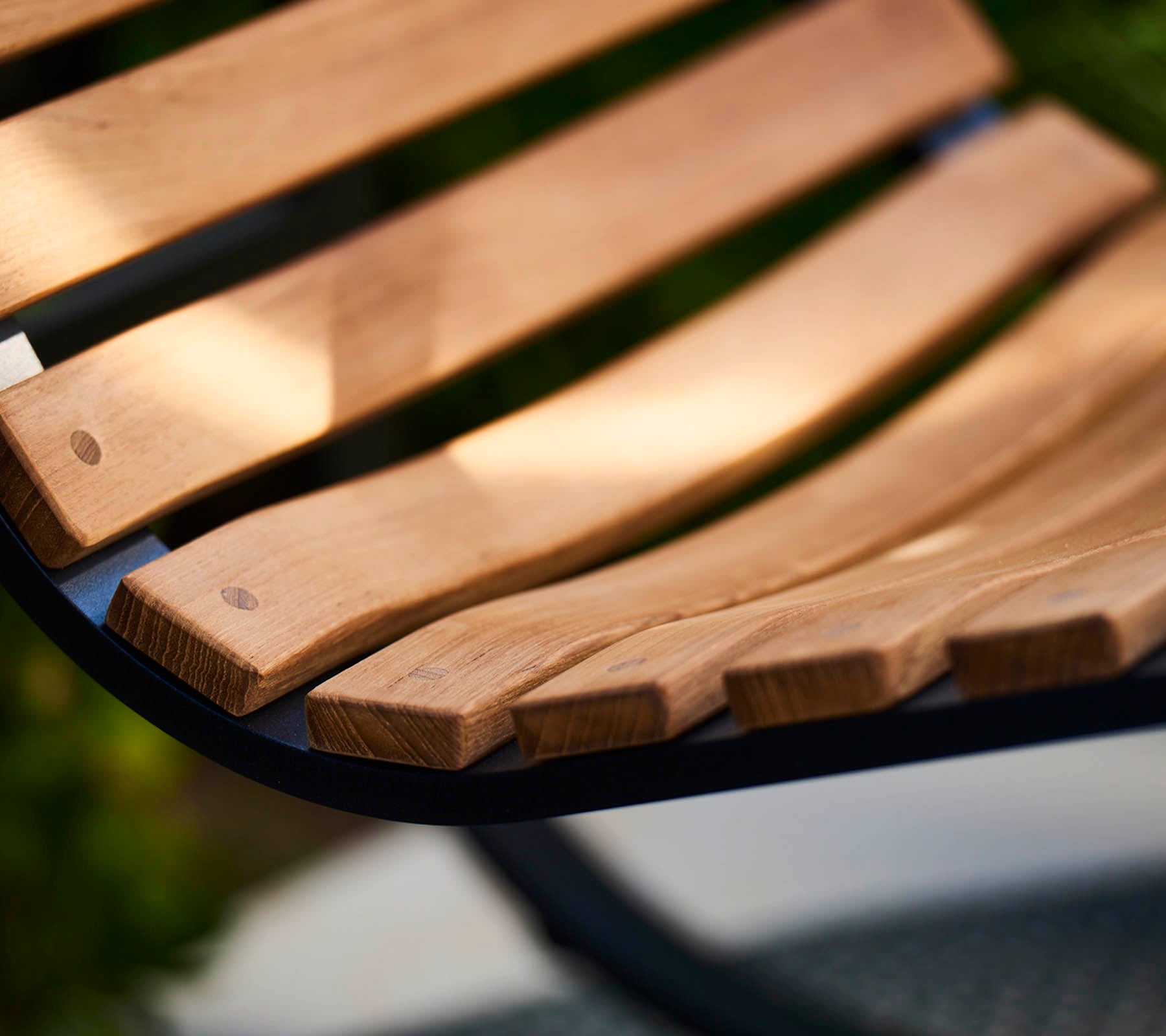 Nærbilde av en bølget treslat med glatt, naturlig treverk, som viser håndverk og et varmt, innbydende design.