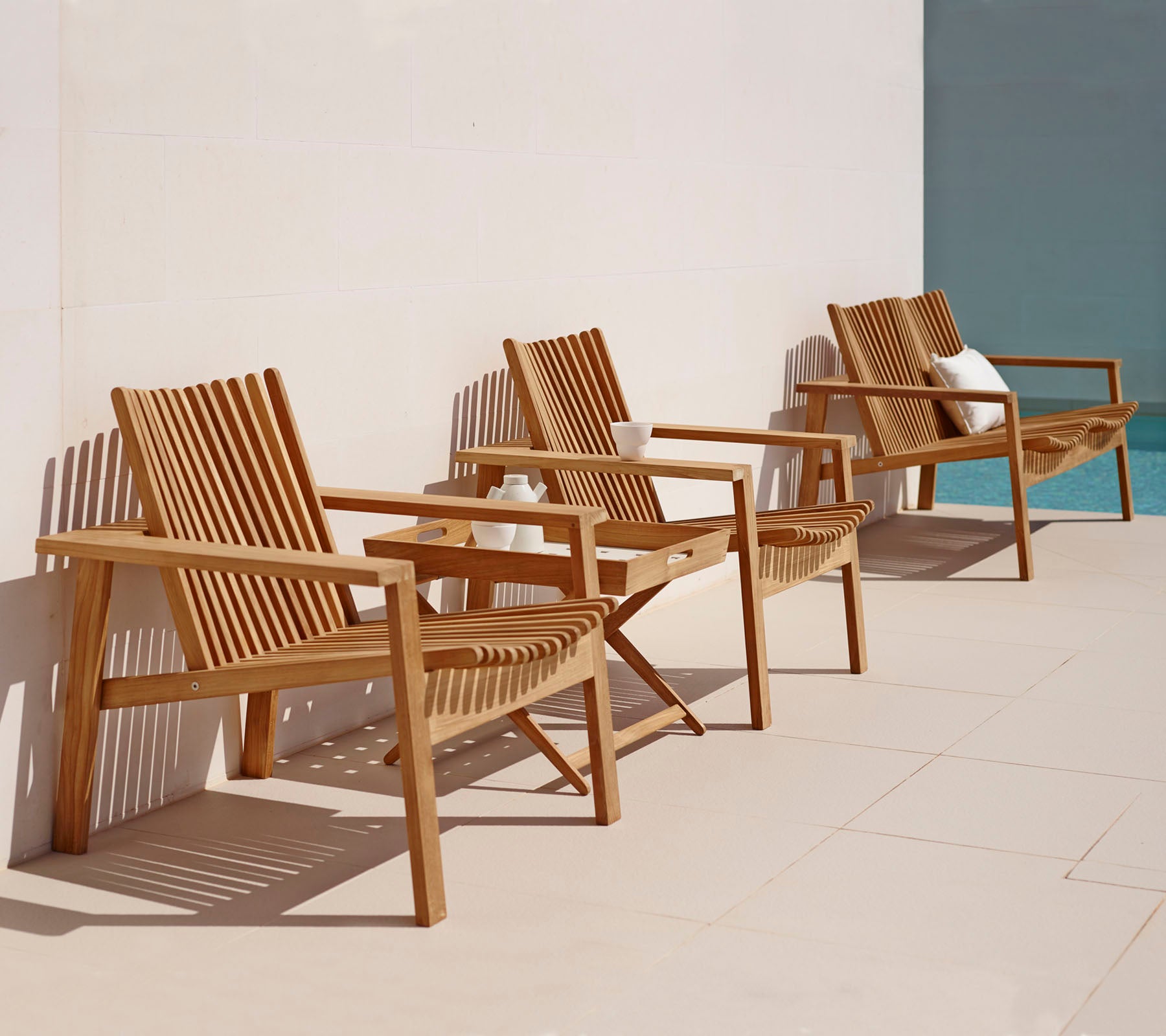 Tre treseterte med lamelledesign ordnet i en rekke, med en enkel, elegant stil som er egnet for avslapning.