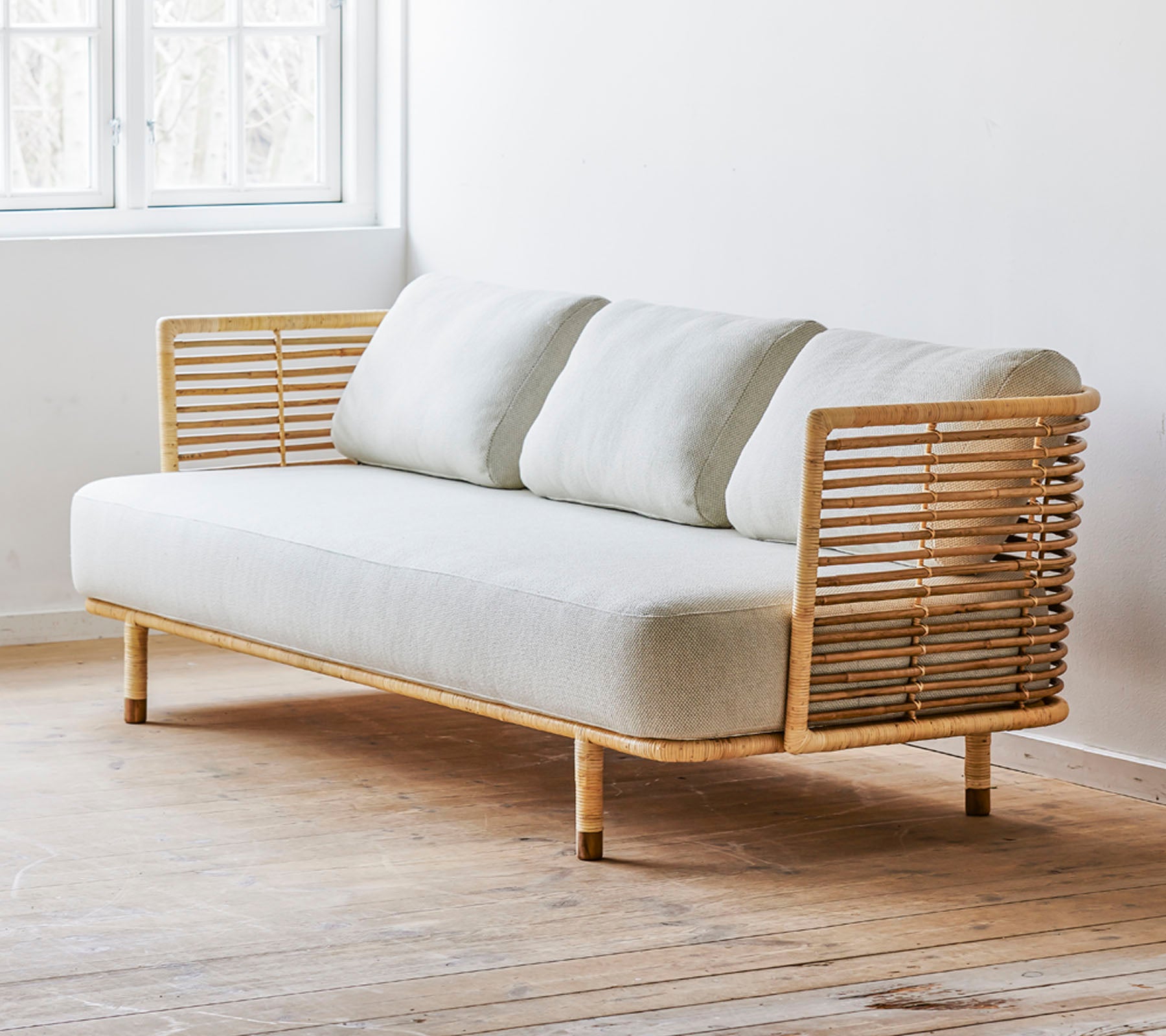En moderne sofa med en strømlinjeformet design, med et lyse stoffsete og stilige tre detaljer. Perfekt for moderne rom.