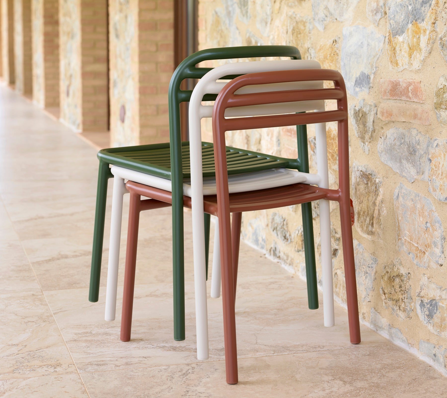 En stabel med Bliss-stoler i forskjellige farger, som viser elegant design og praktisk plassbesparende lagring.