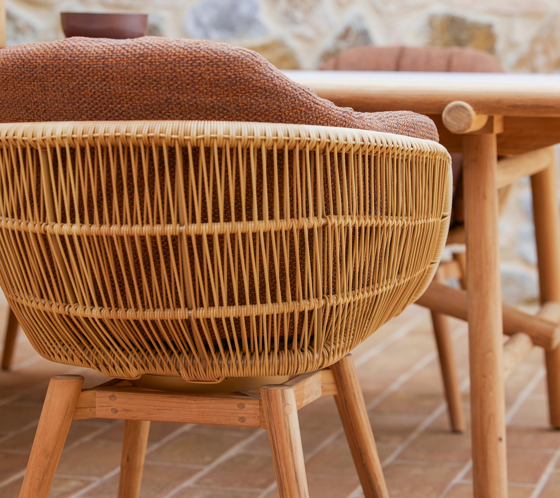 Svingbar spisestol med et vevd design og ben i teak, med en komfortabel Rice-pute for ekstra stil og komfort.