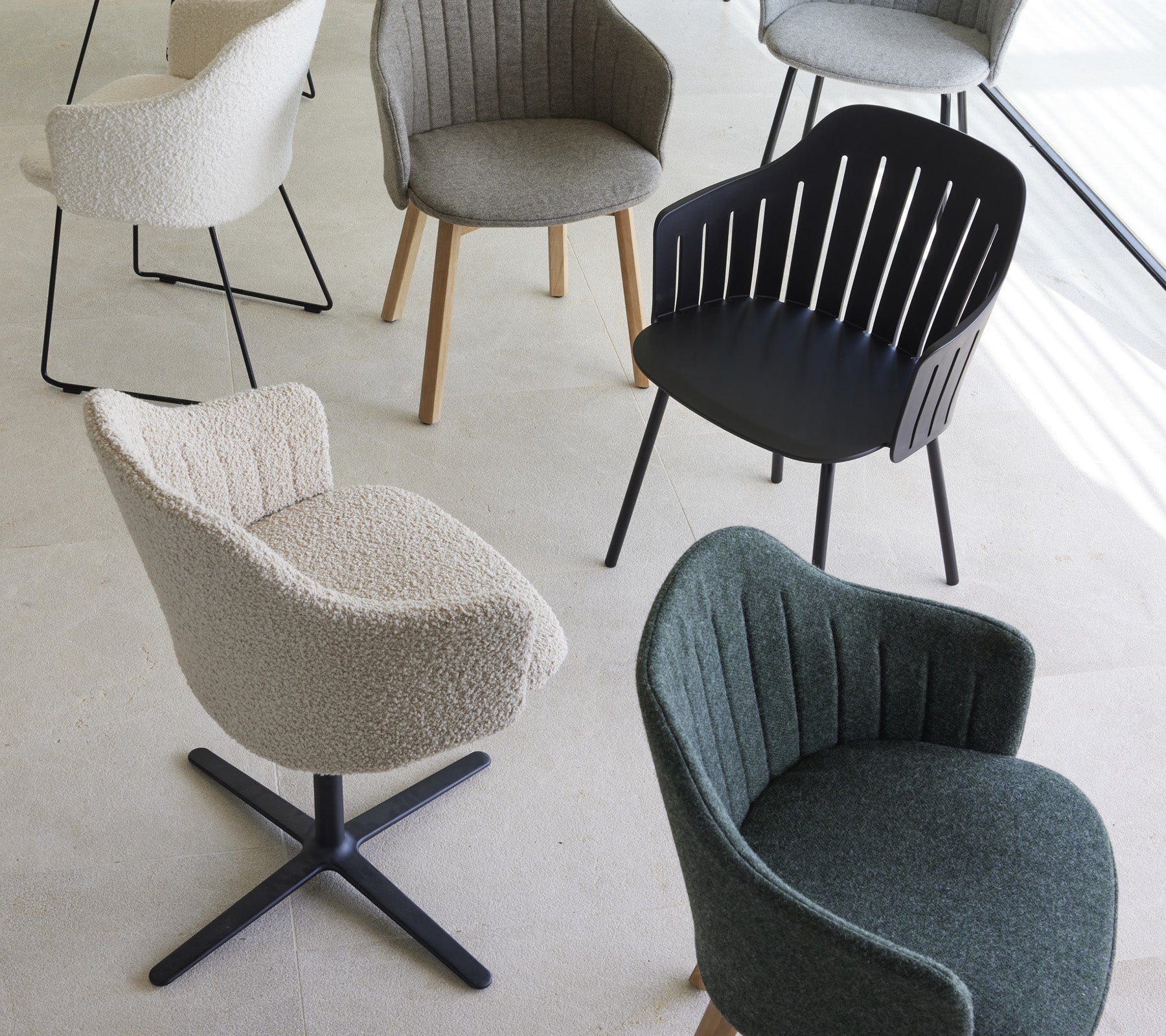 En samling stilige stoler i forskjellige design og farger, med unike teksturer og former, egnet for moderne boarealer.