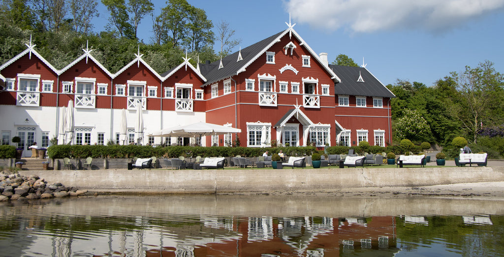 Dyvig Badehotel i Danmark, med sin røde og hvide facade bygning, placering i natur med havudsigt