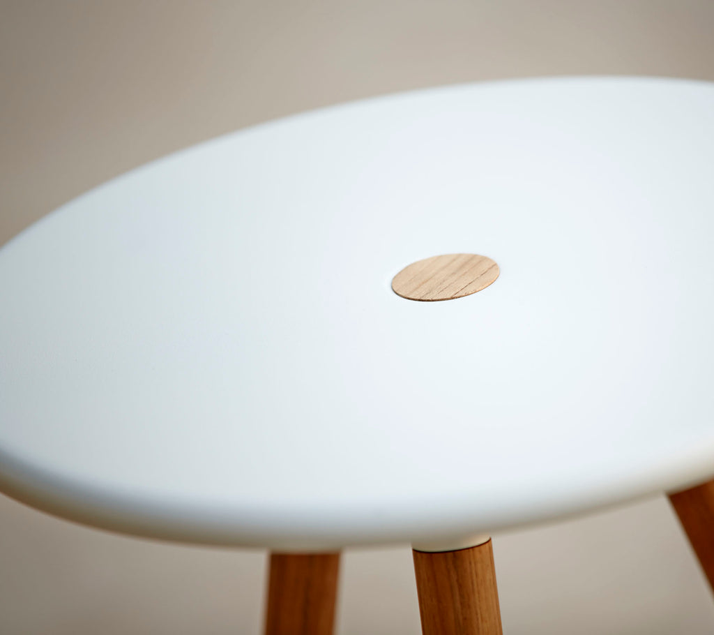 En stilren krakkel med en jevn hvit topp som har en liten trekant, støttet av treben. Ideell for moderne innredning.