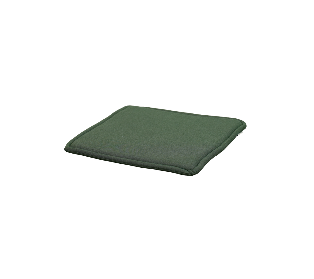 Lys grønn pute plassert på en flat overflate.