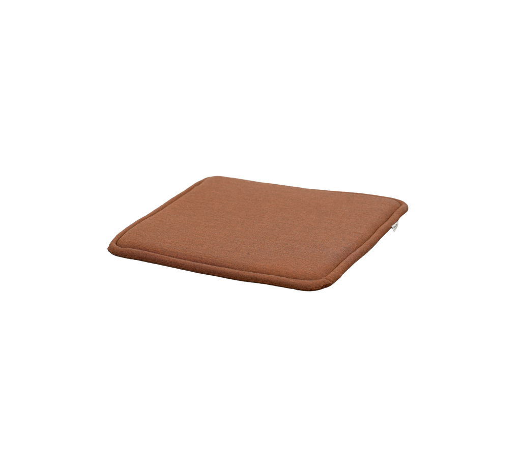 ørkenrød pute med kvadratisk form og subtil tykkelse.