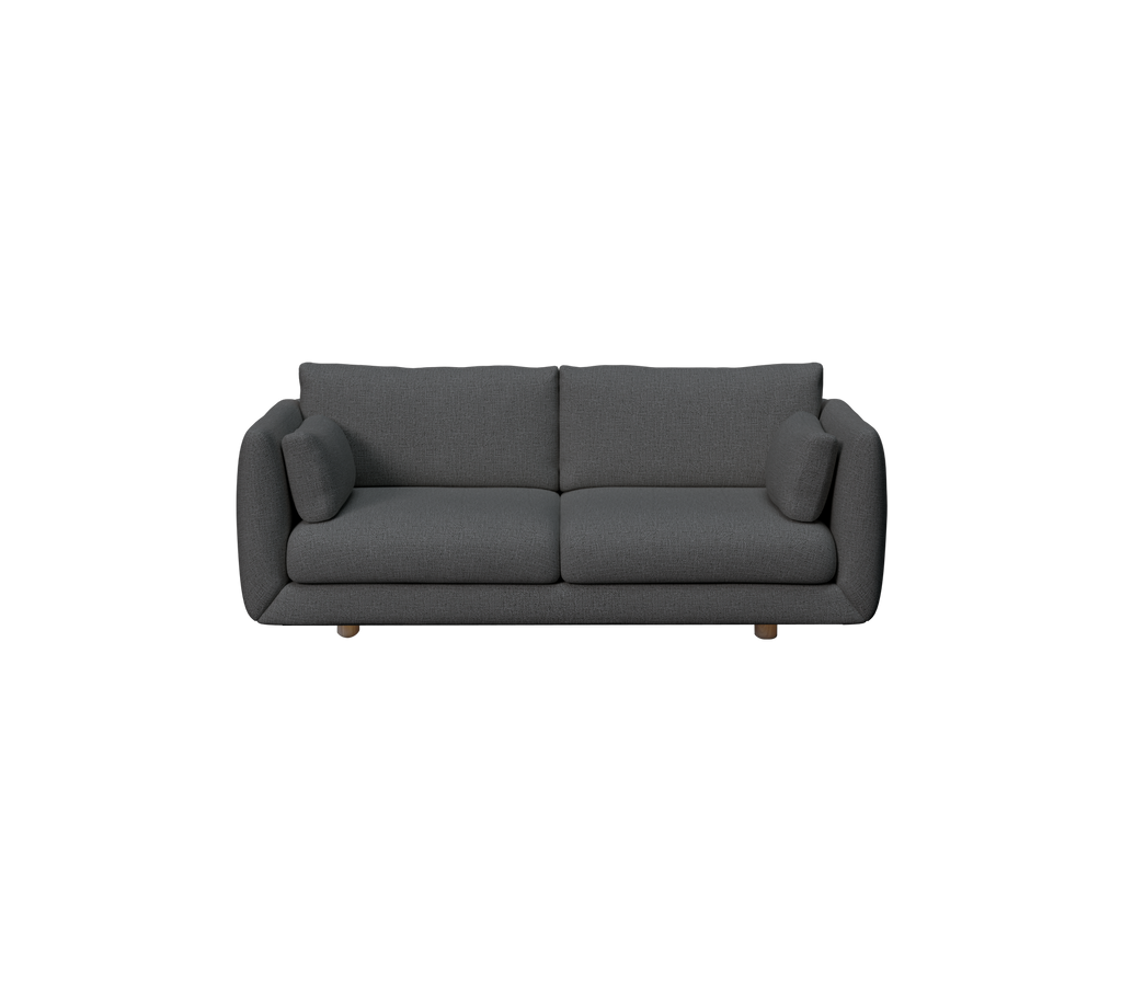 Mørkegrønn sofa med to puter i en moderne loungeinnstilling.