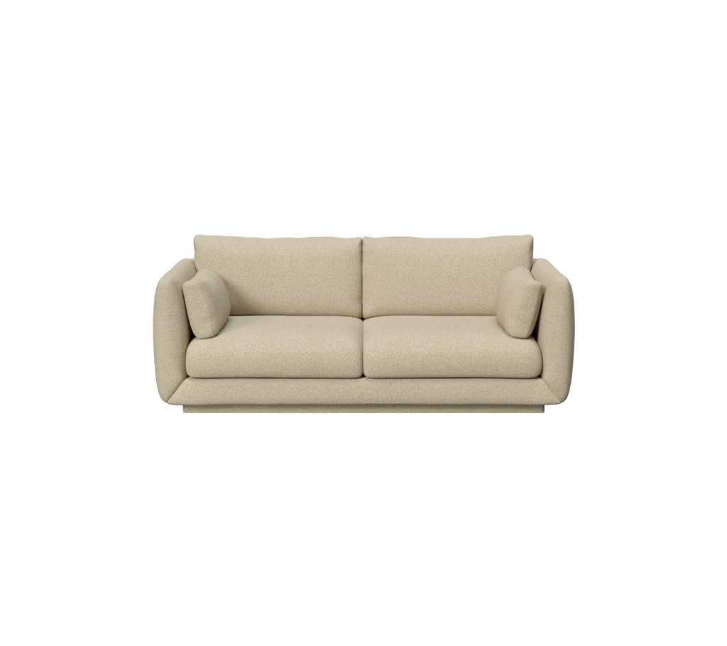 Lyst brunt sofa med avrundede kanter og to puter.