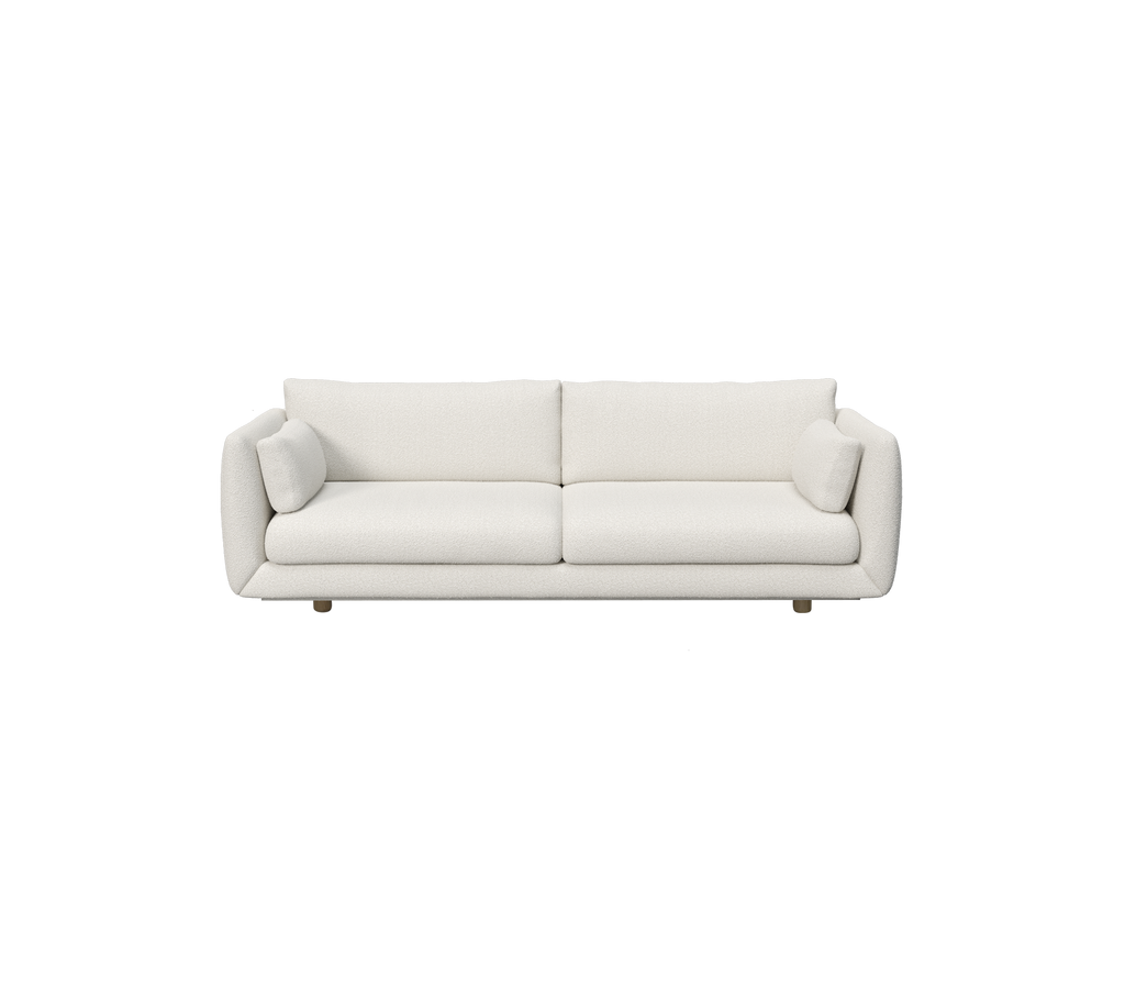 Moderne hvit sofa med sylinderformede puter.