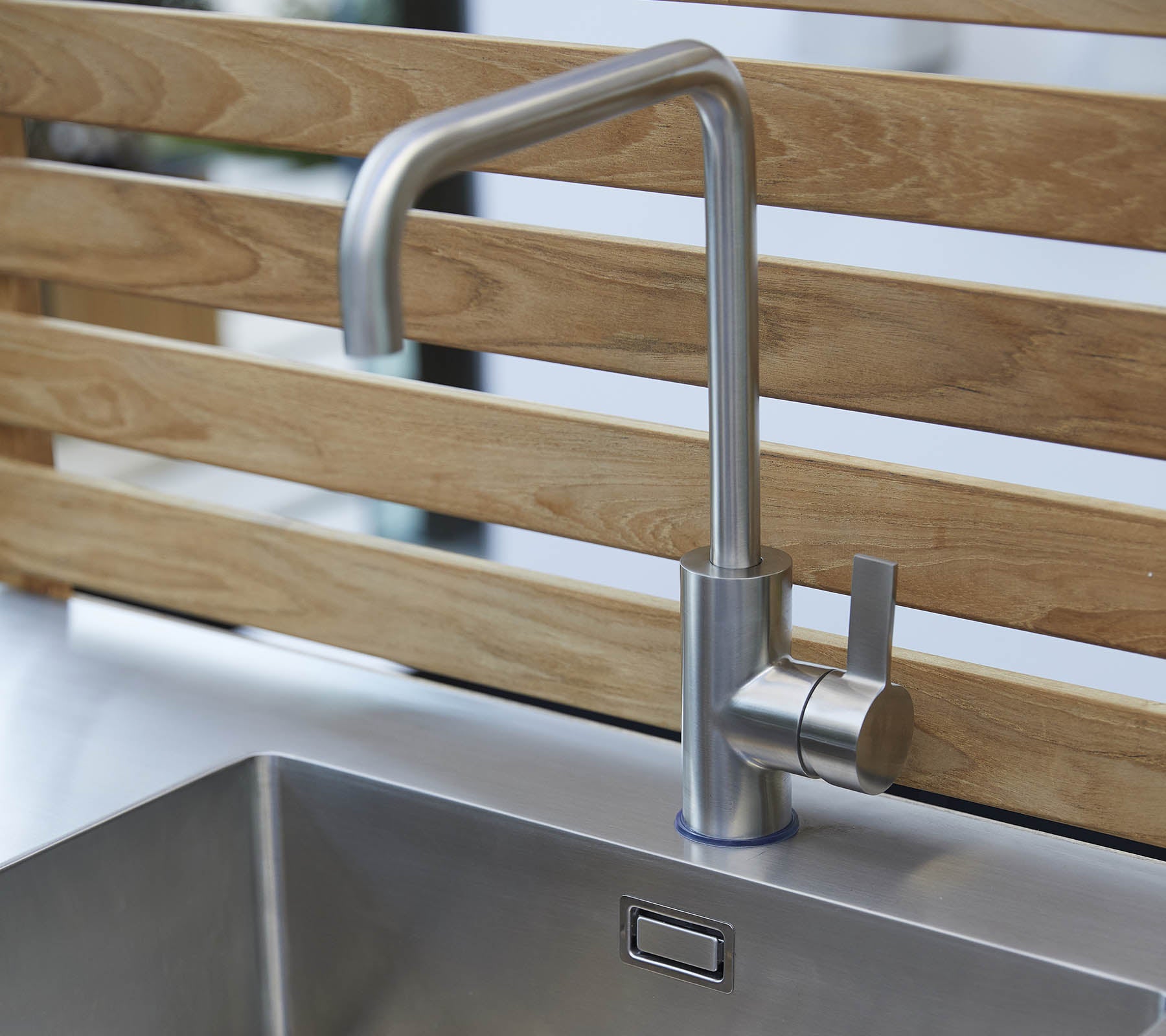 Stilig kjøkkenkran i rustfritt stål med et slankt design og enkelt håndtak, plassert over en moderne vask.