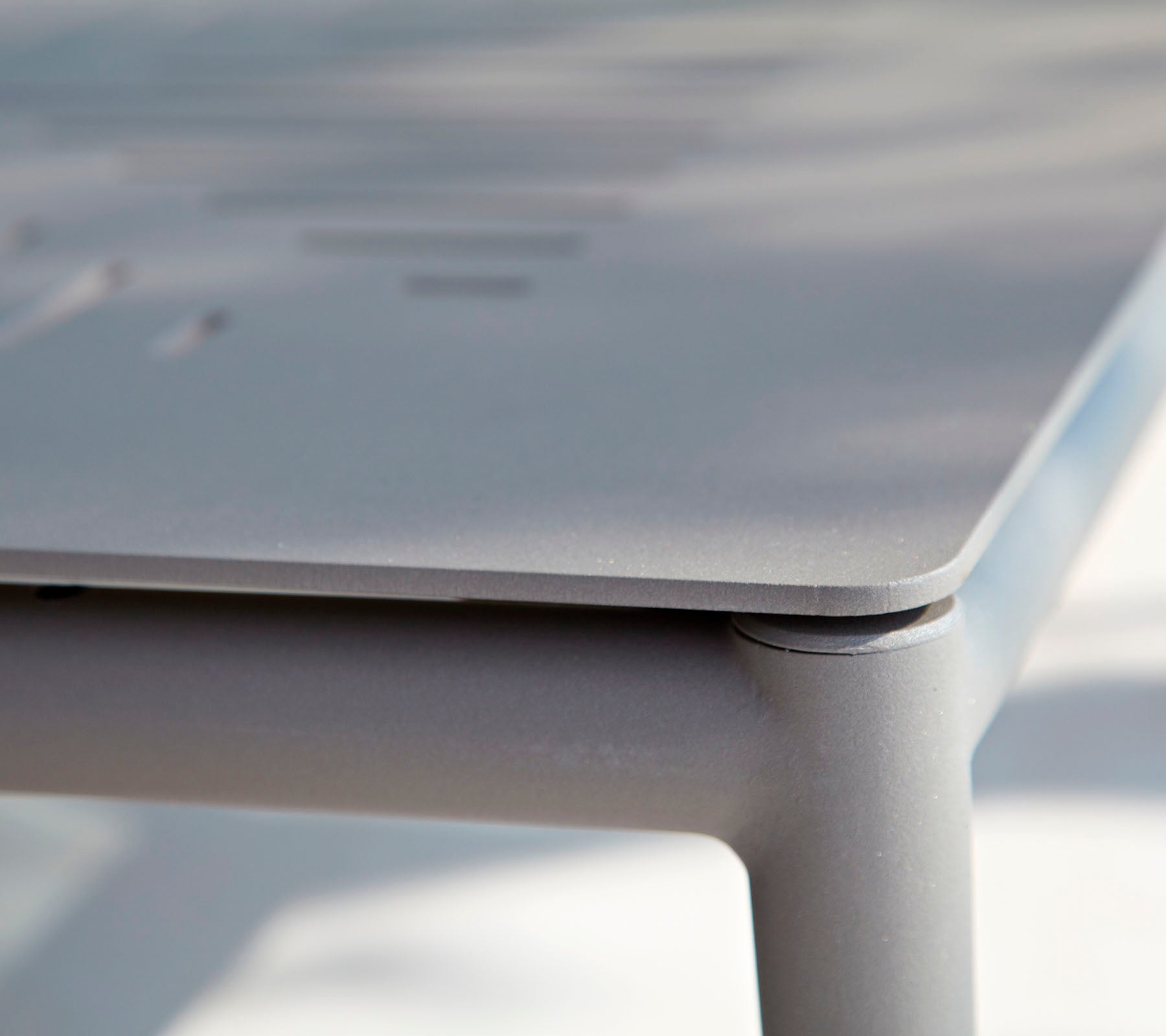 Nærbilde av et elegant, moderne bord med en glatt overflate og subtile detaljer. Designet fremhever rene linjer og minimalistisk stil.