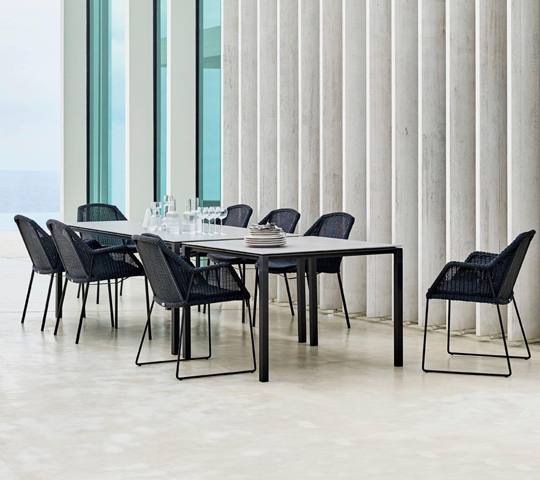 Et moderne spisestuebord med svarte stoler plassert rundt, med minimalistiske designelementer og en elegant bordinnstilling.