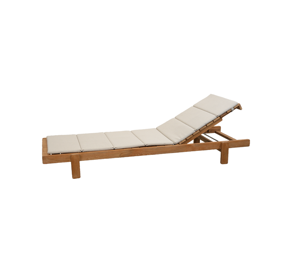 Teak-lounge stol med sandpute i en moderne utendørs setting.