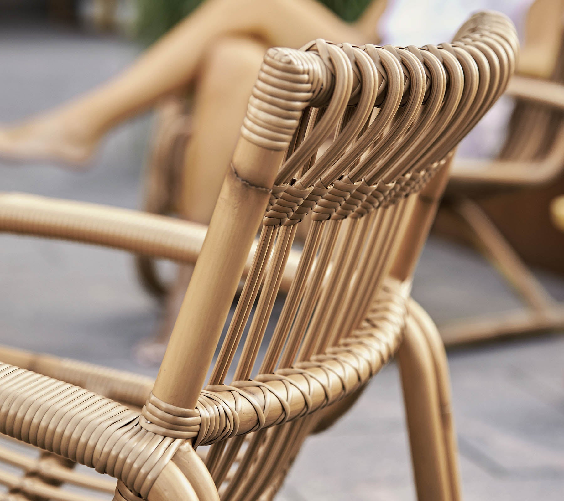 Nærbilde av en stilfull flettet stol med moderne design, som viser detaljert håndverk og naturlige materialer.