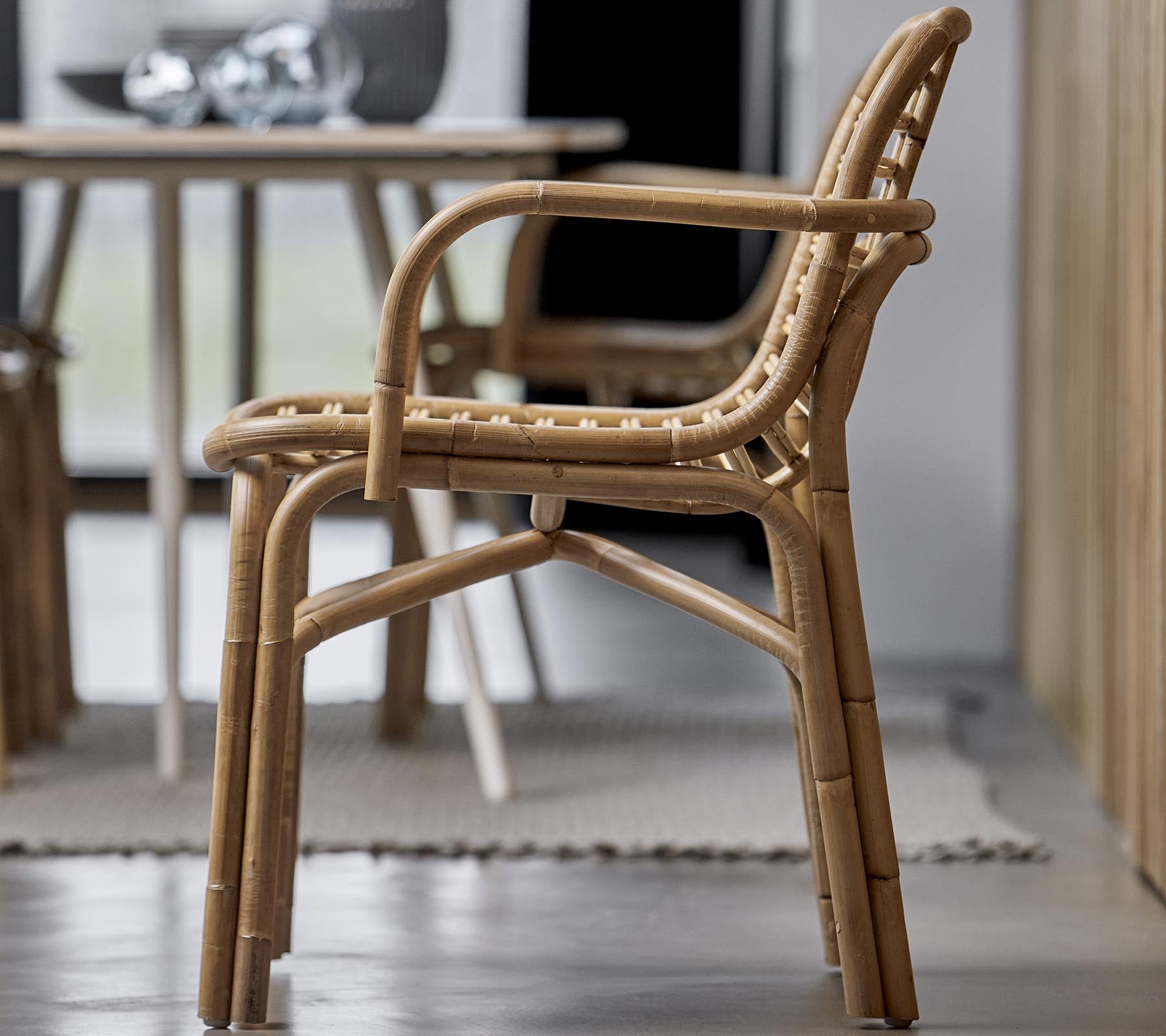 En stilig stol laget av naturlige materialer, med et vevd design og armlener, passende for ulike interiørmiljøer.