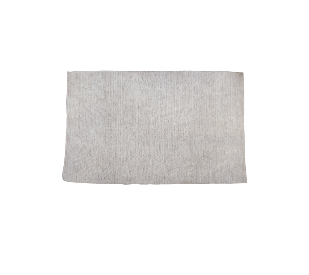 Flerfarget teppe i en sandtone med teksturert overflate.