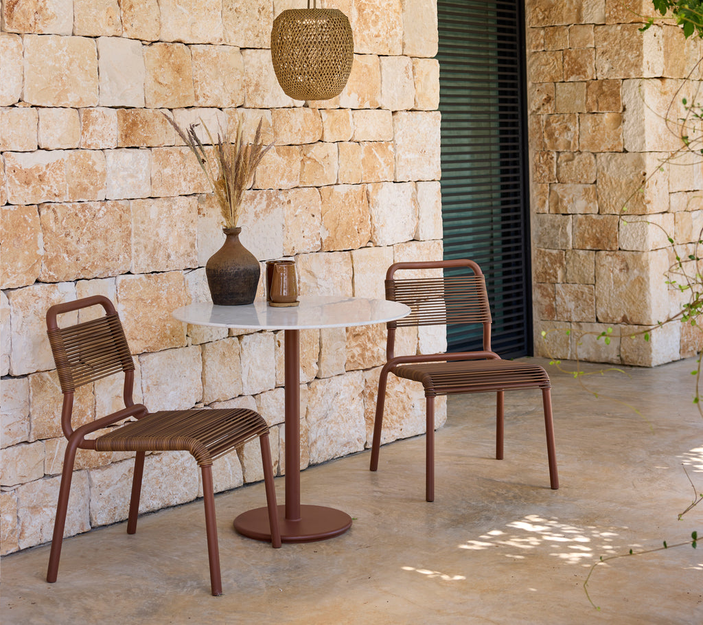 Moderne loungeoppsett med brune stoler og et hvitt bord.