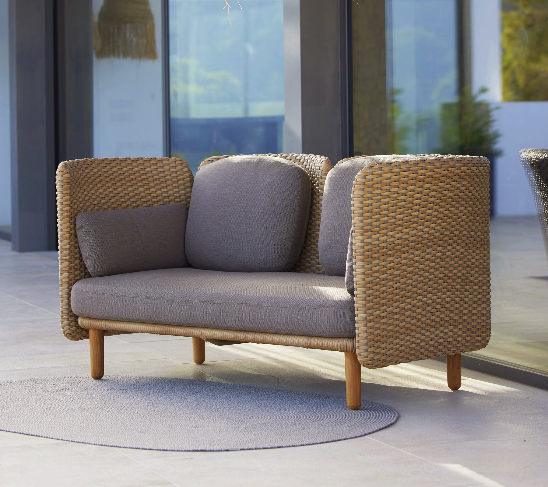 Arch 2-seters sofa med lav ryggstøtte, vevde sider og nøytrale puter, som blander komfort med moderne design.