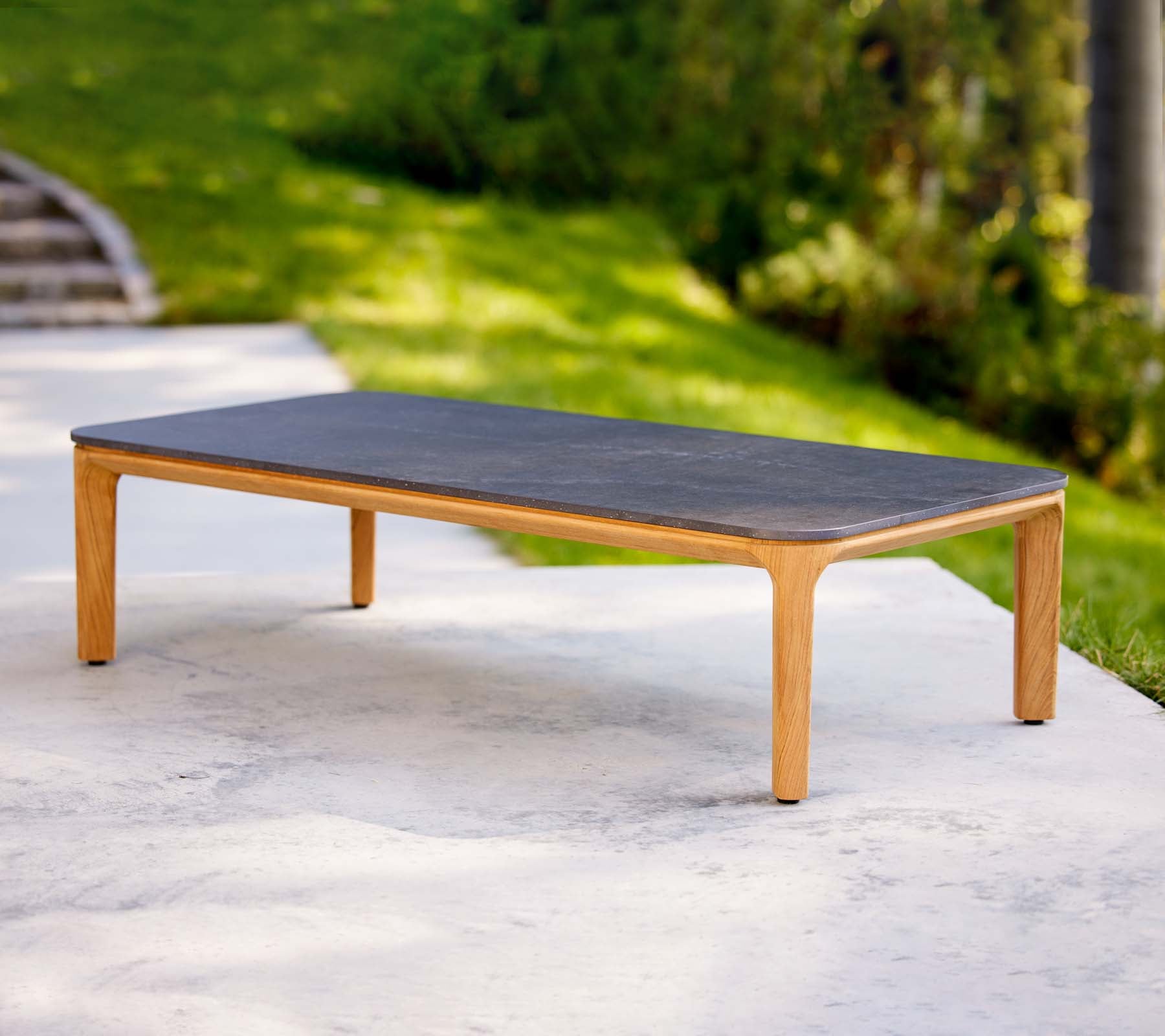 Et elegant kaffebord med en mørk overflate og lyse trebena, ideelt for moderne stuer.
