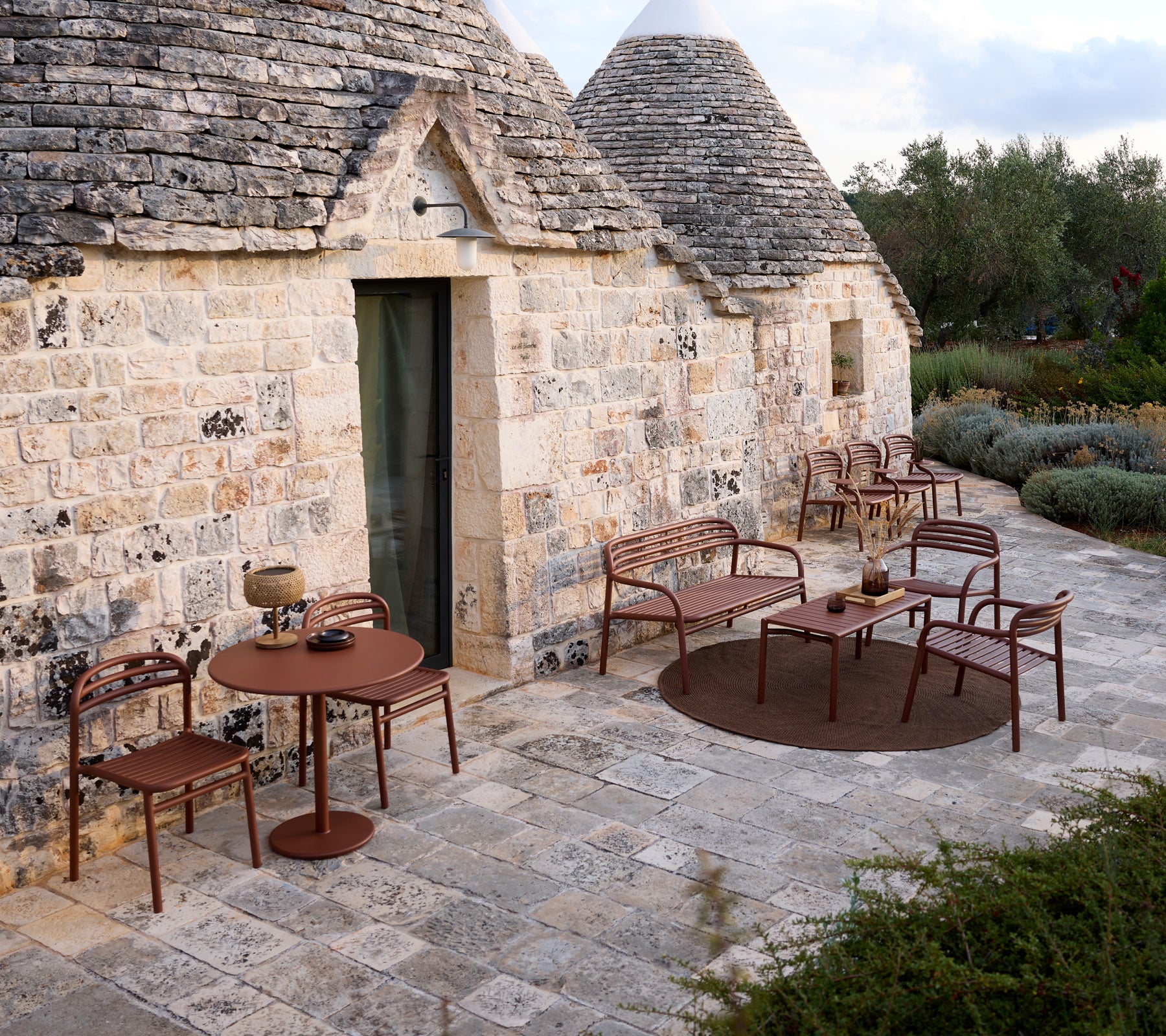 Utendørs setting med et brunt bord og stoler i moderne design.