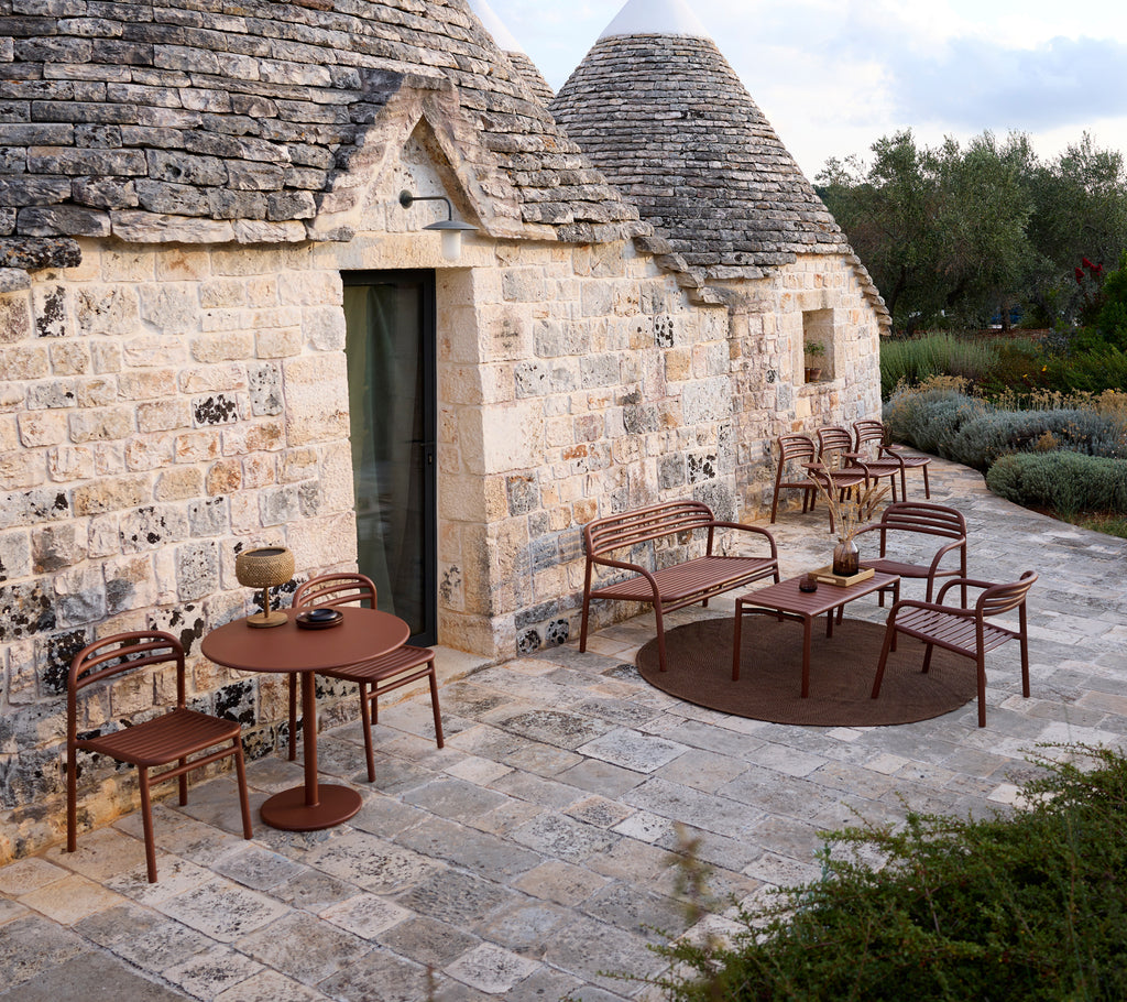 Utendørs setting med et brunt bord og stoler i moderne design.