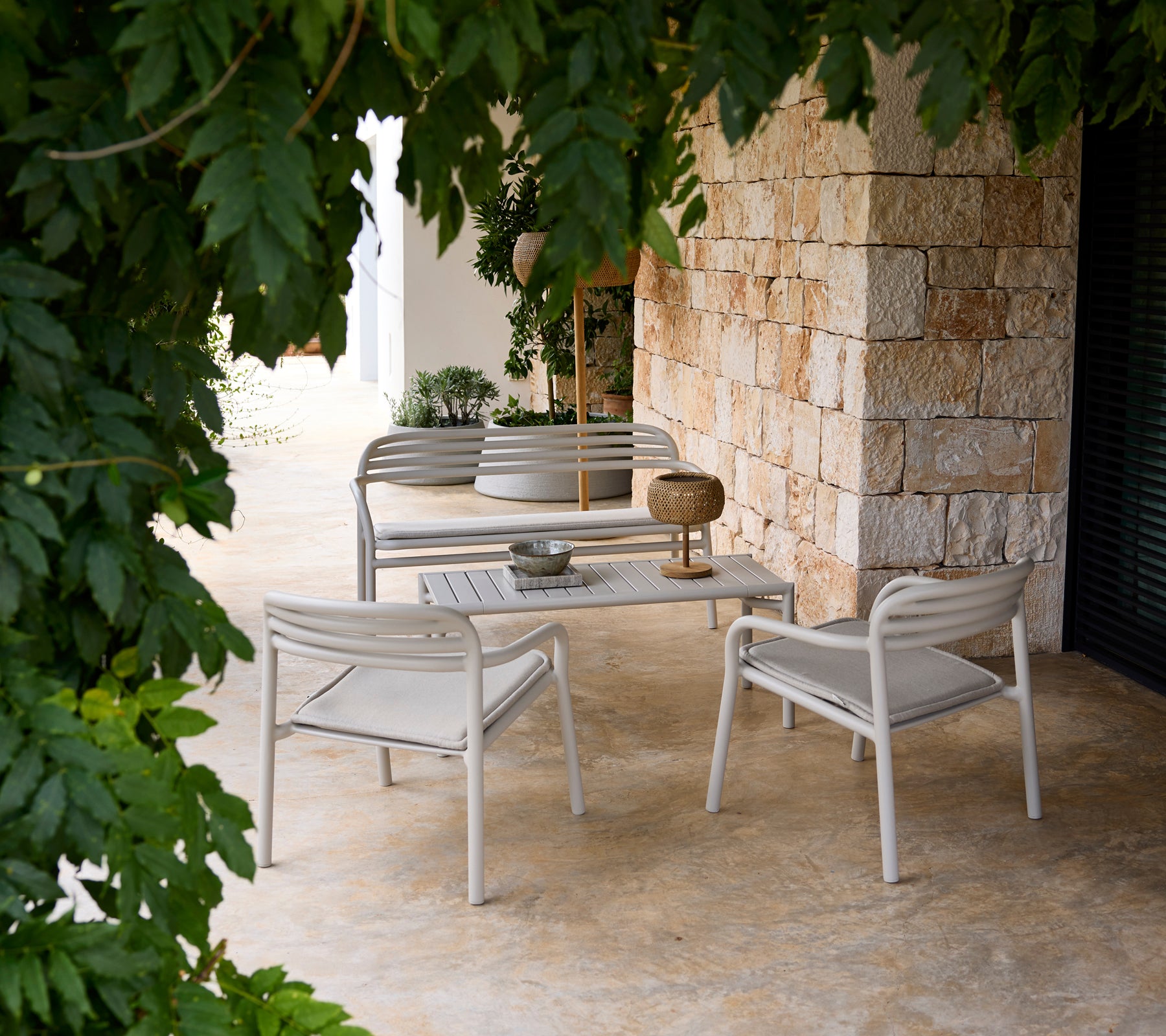 Grå sofa og stol med et hvitt bord i en moderne loungeinnredning.