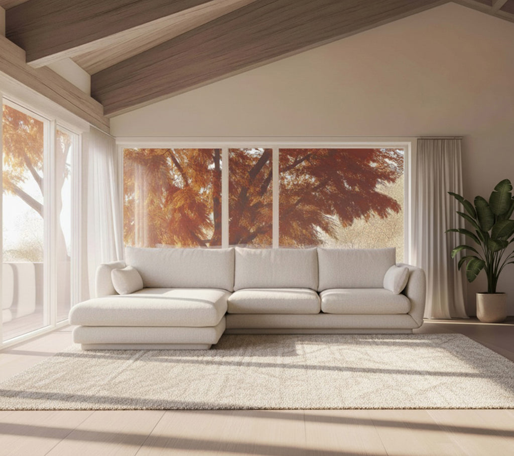 Moderne hvit sofa og beige teppe i et minimalistisk loungeoppsett.