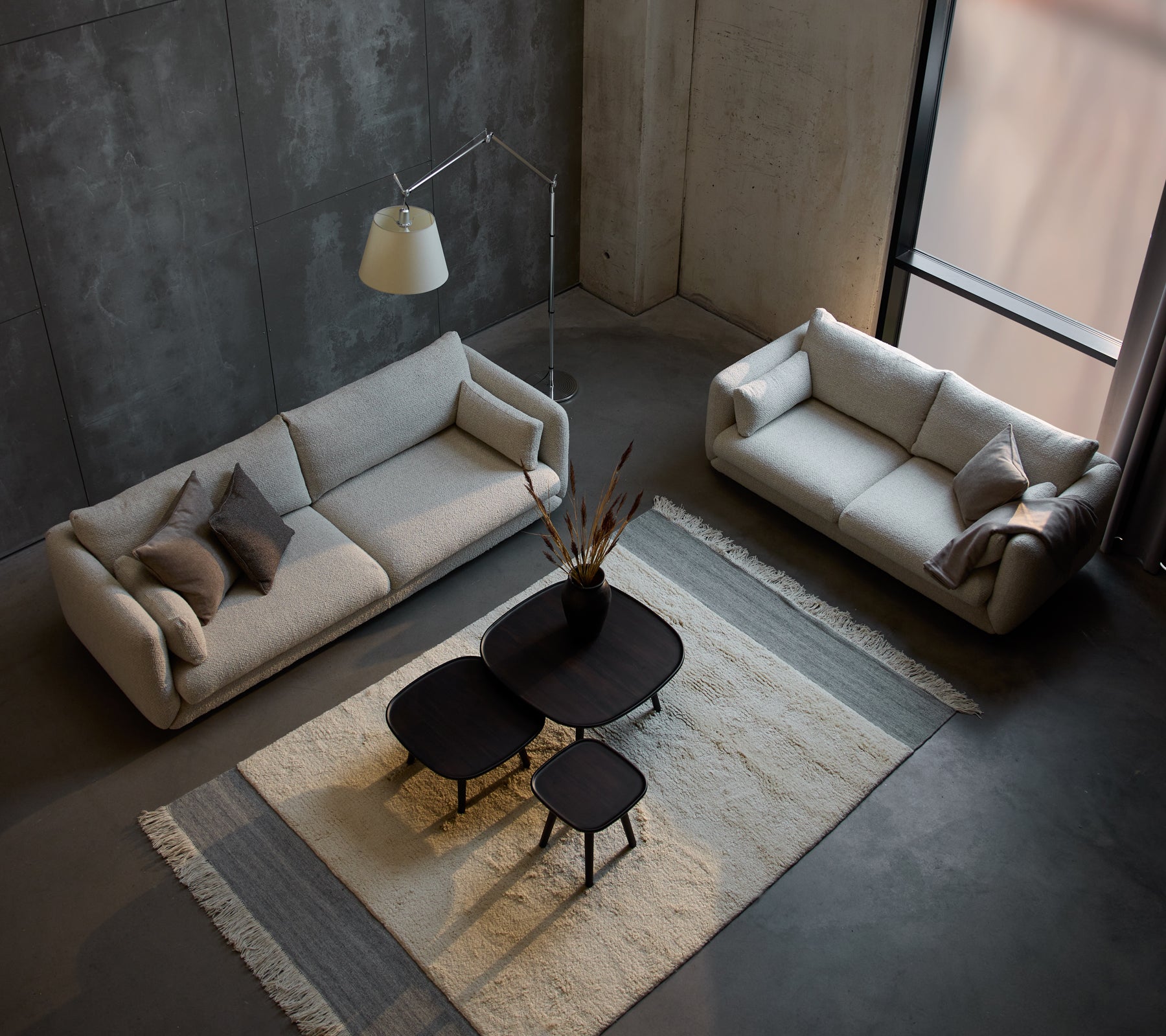 Et moderne sitteområde med en Bloom 3-seters sofa, en mindre 3-seters sofa og stilige Pace kaffebord på et teksturert teppe.