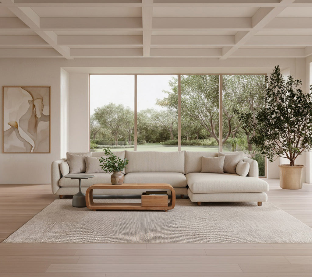 Moderne stue med en beige sofa, et trebord og en grønn plante.