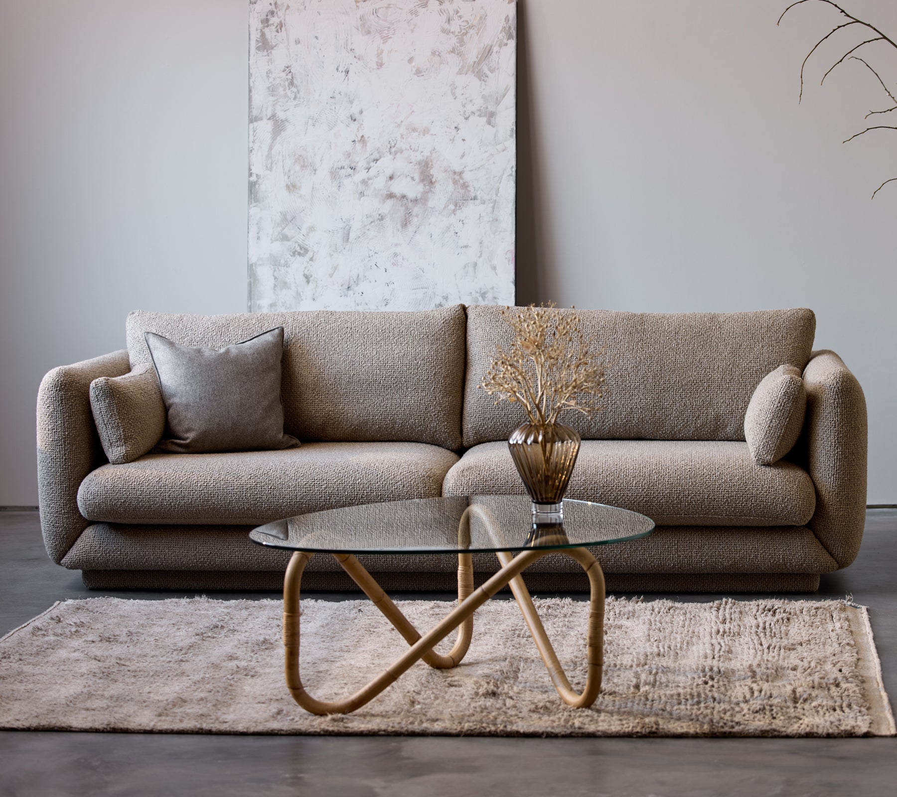 Bloom 3-seters sofa i taupe flair med sokkel, sammen med et Wave innendørs kaffebord og en dekorativ vase, på et mykt teppe.