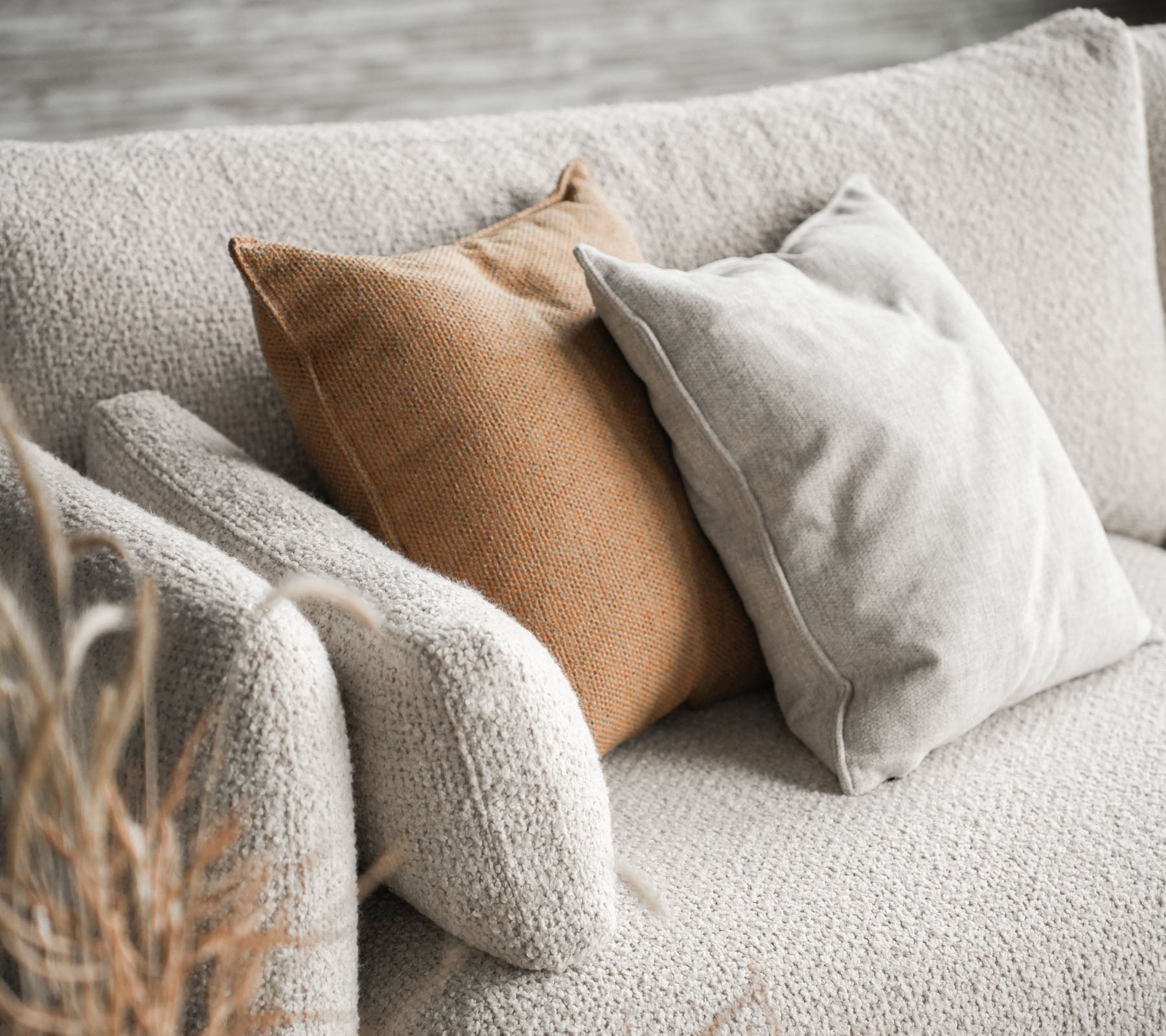 Koselig sofa med Bloom i sandfarge med to puter, en i beige og den andre i varm brun, som gir et stilig preg.