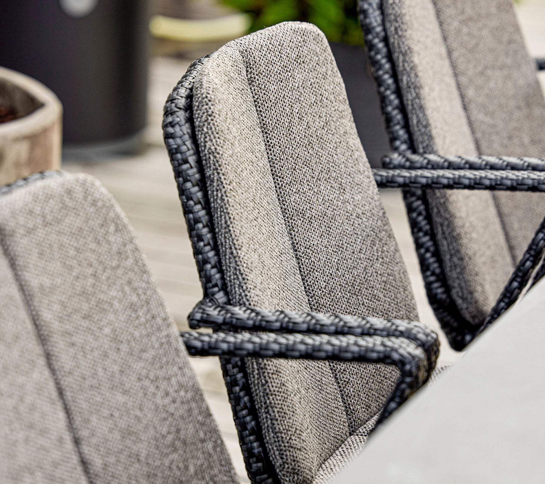 Nærbilde av stilige stoler med teksturert stoff og elegante tau-detaljer, passende for moderne utesitting.