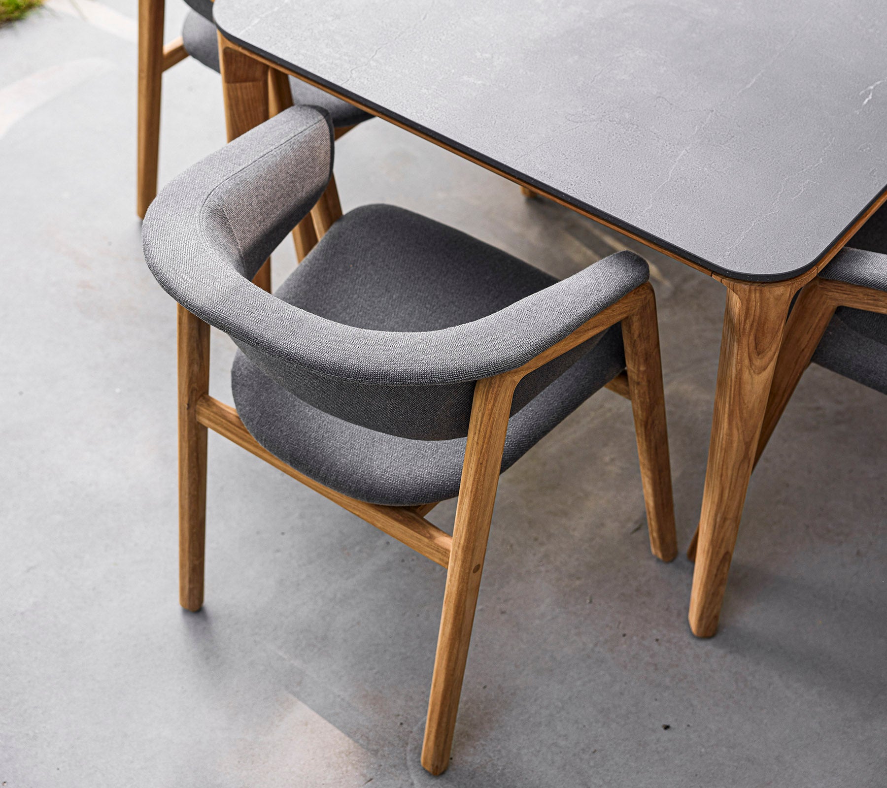 Stylish stol med ramme av tre og myk grå polstring, designet for komfort og eleganse. Perfekt for moderne spisestuer.