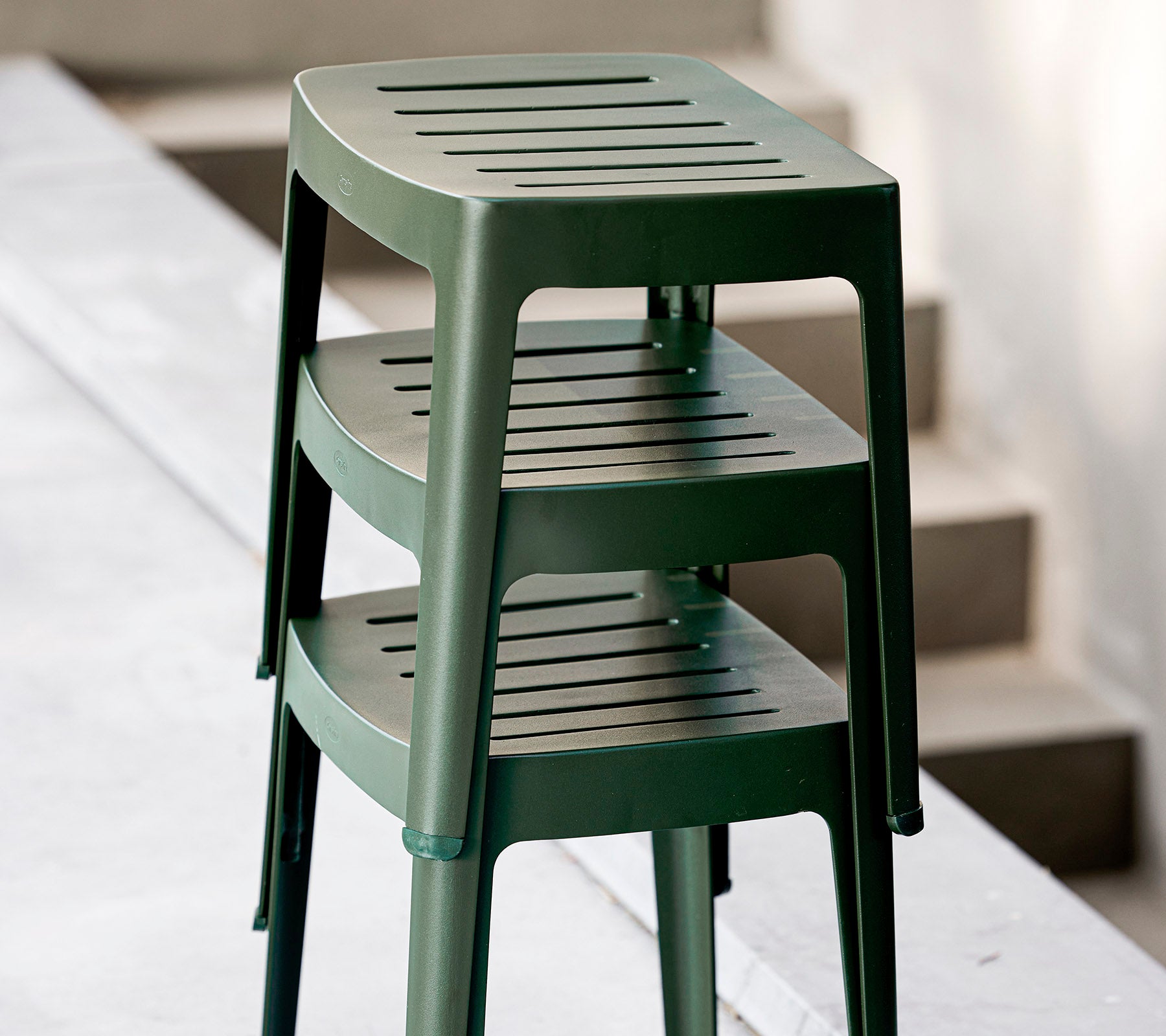 Stablede grønne plaststoler med slissede seter, designet for uformell bruk. Ideelle for allsidige sitteordninger.