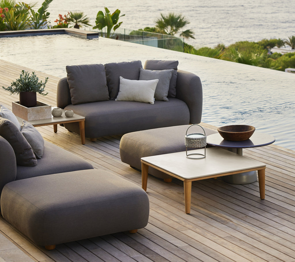 Moderne ute lounge møbler med grå sofa, stol og tremmeskaft.