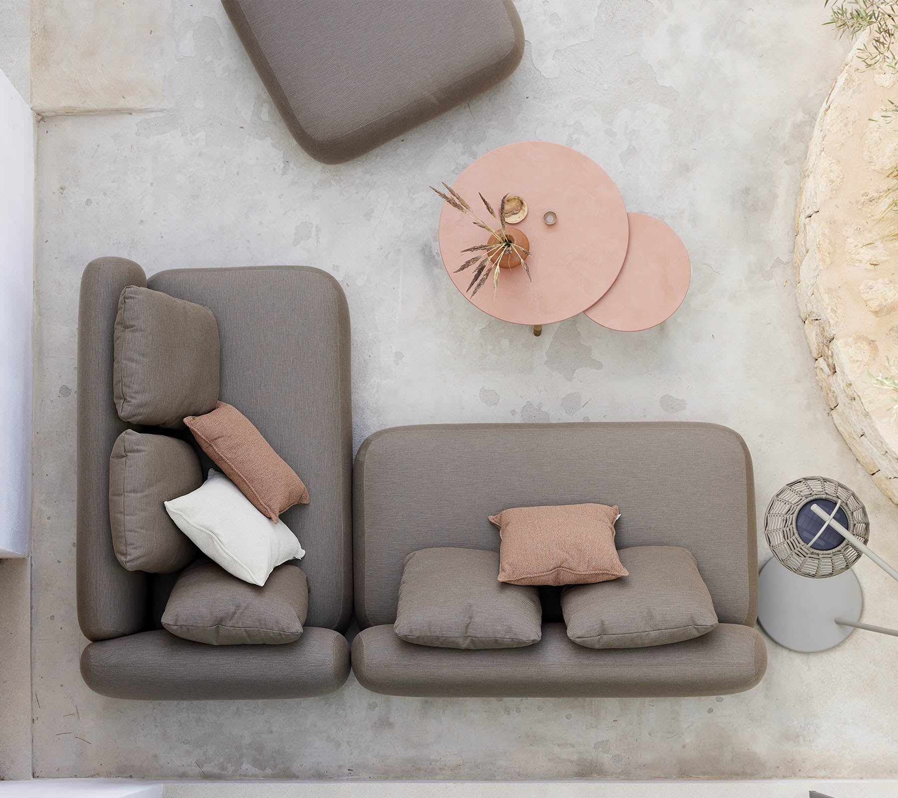 Et stilfullt sittearrangement med en nøytralfarget sofa med dekorative puter, sammen med et unikt twist-kaffebord.