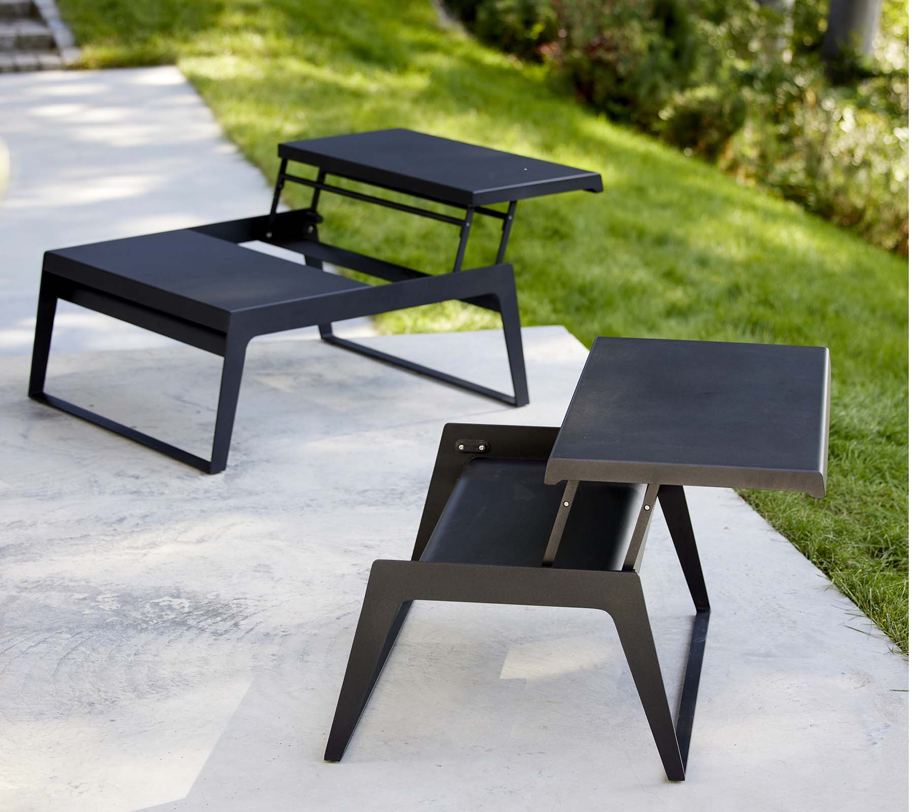 To moderne chill-out kaffebord med slanke design og minimalistisk svart finish, som viser allsidighet i stil og funksjonalitet.