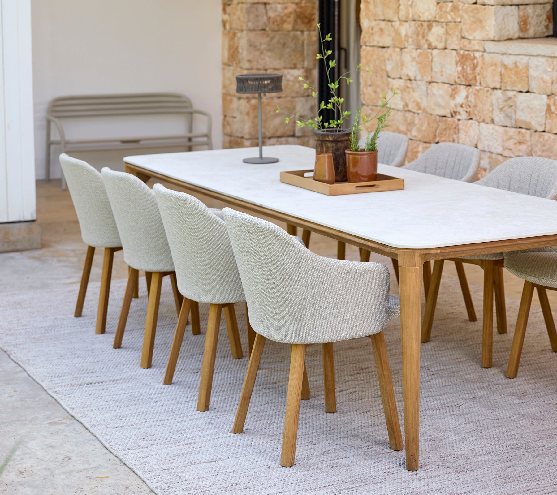 Moderne spiseoppsett med et hvitt bord og beige stoler.