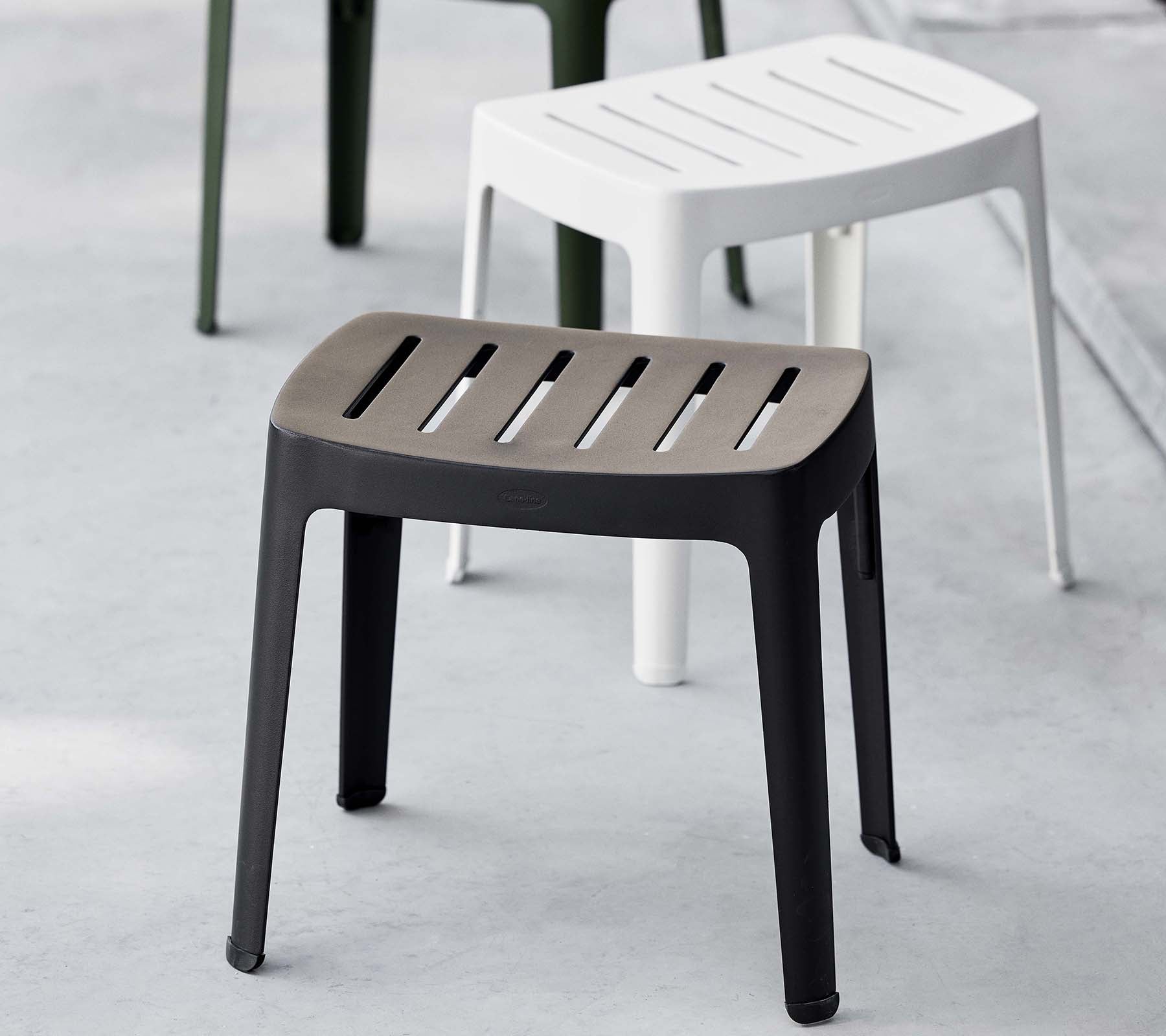 Stilig krakkel i svart med ribbet topp, med moderne design; komplementert av en hvit krakk i bakgrunnen.