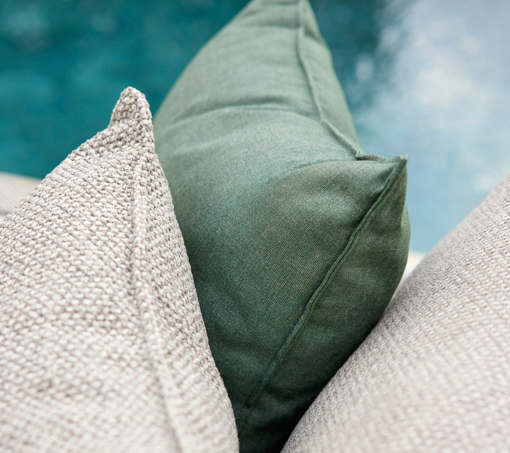 Grønne og grå puter arrangert sammen.