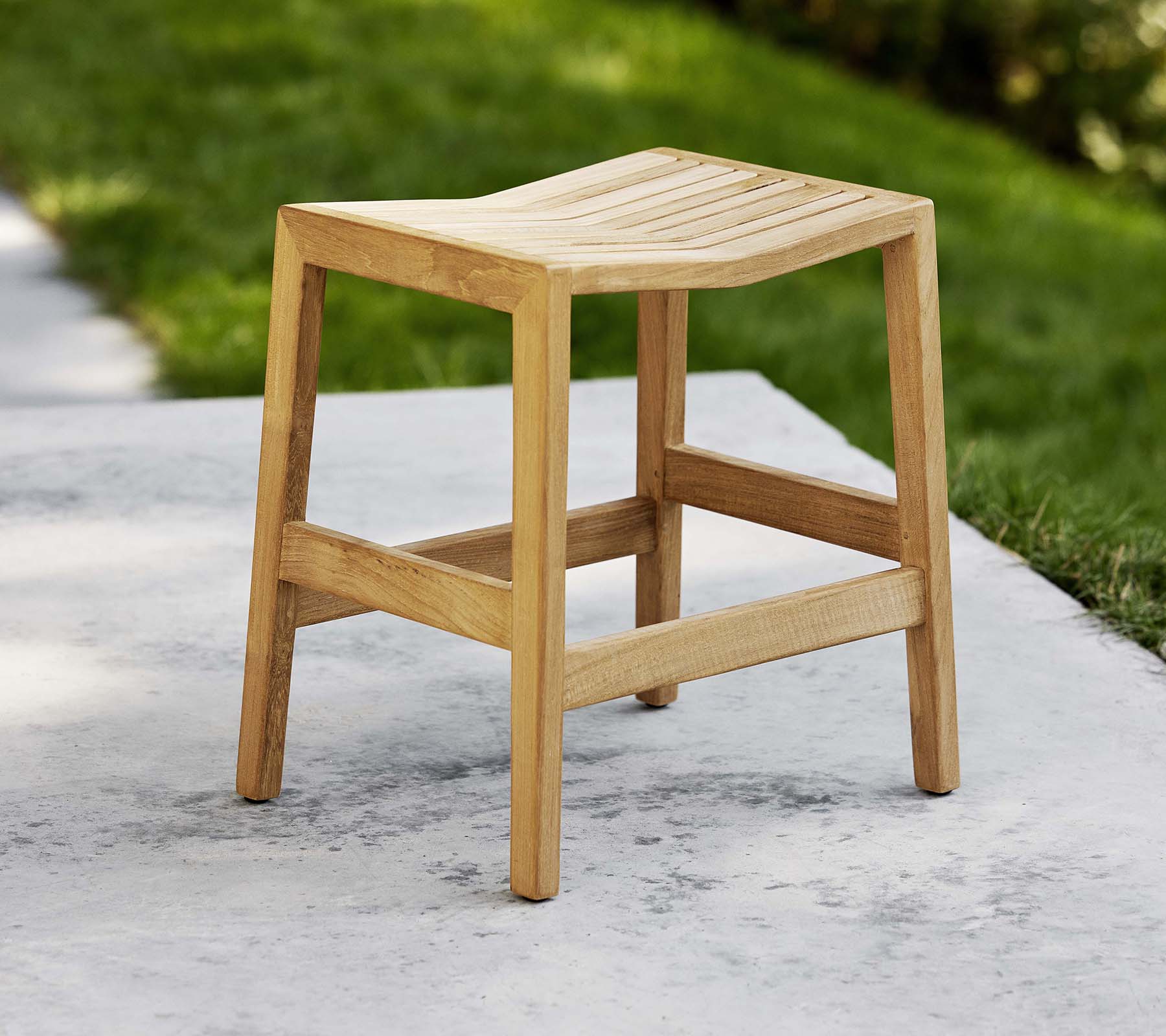 En treflipstol med lamellsete og robuste ben, designet for allsidig sitteplass eller dekorativ bruk.