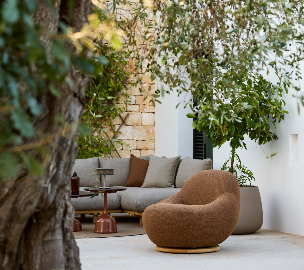 Moderne loungeområde med en brun stol og en grå hjørnesofa.