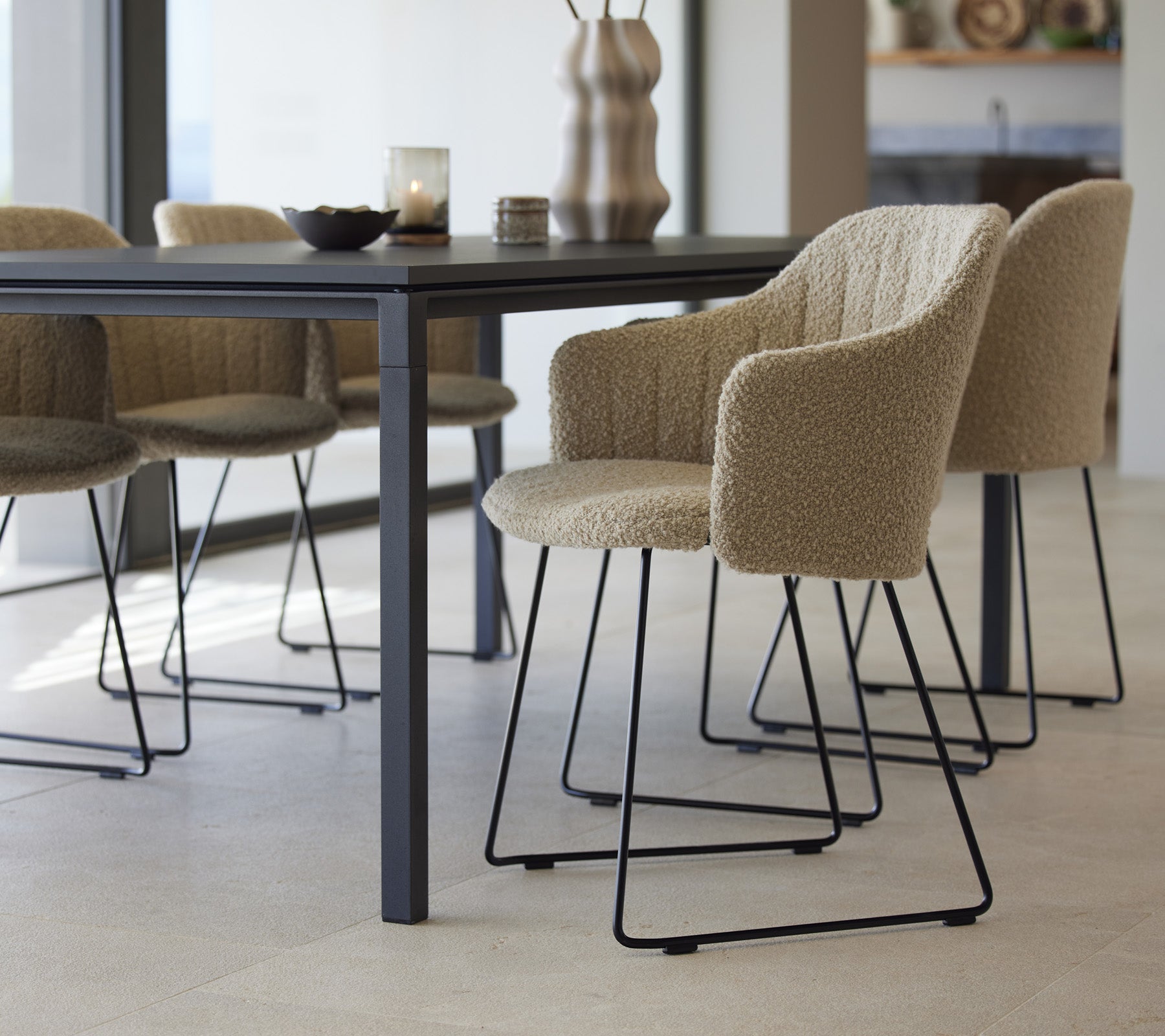 Et stilfullt spisebord med teksturerte stoler, med moderne design og minimalistiske elementer, klart for en innbydende spiseopplevelse.