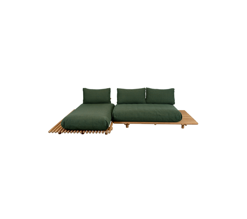 Moderne mørkegrønn sofa med teakbase i en loungeinnstilling.