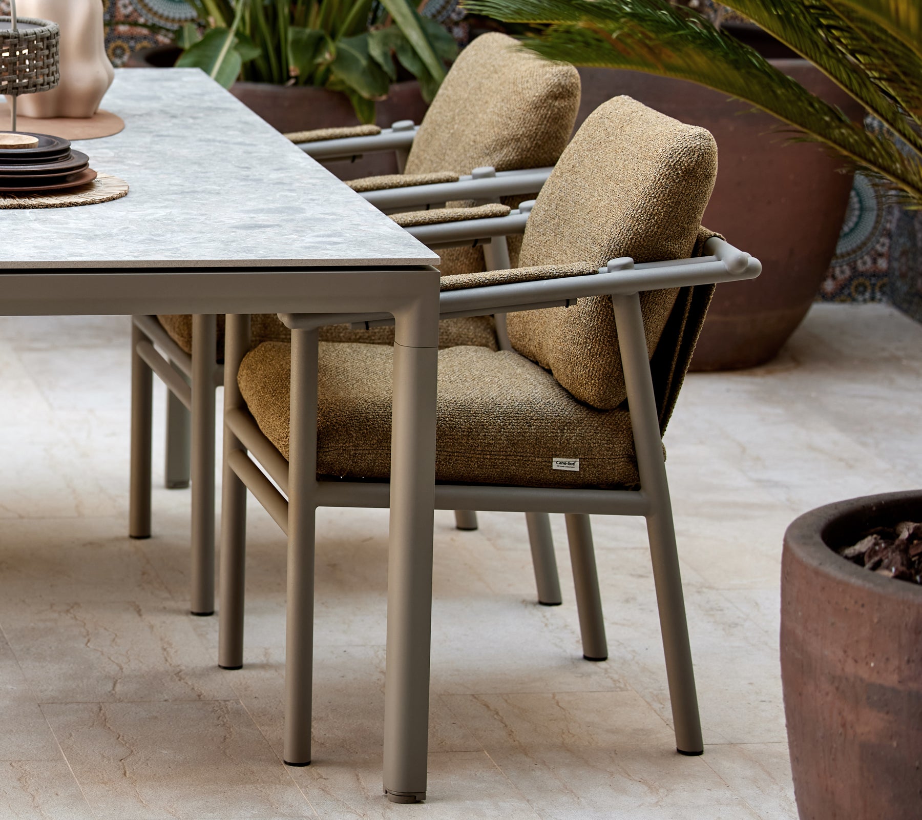 To spise stoler med myke puter, med et moderne design med robuste bein, plassert ved siden av et bord med dekorative gjenstander.
