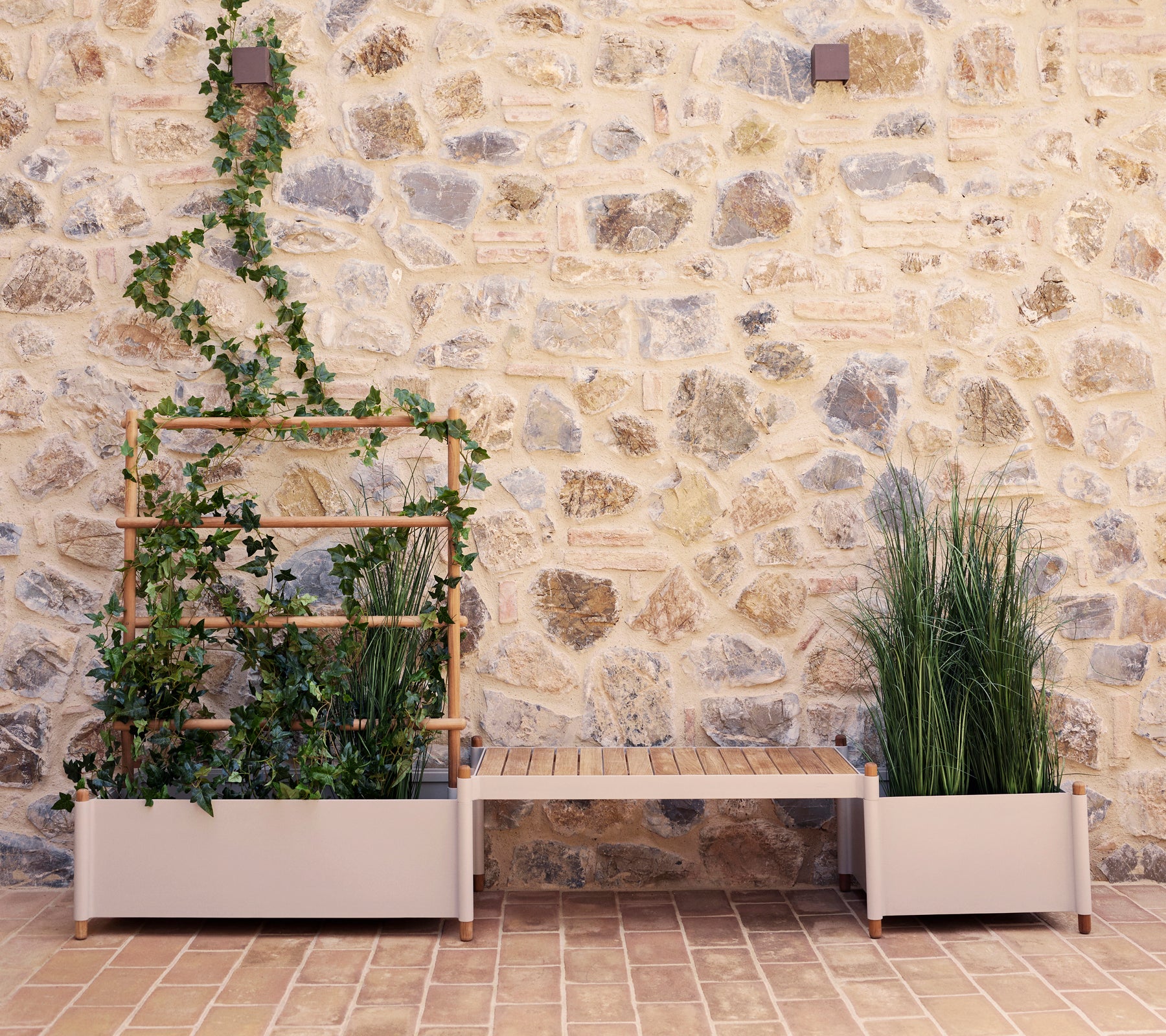 Sticks plantebenk med grønt mot en steinvegg, med et vertikalt plante stativ og to store plantekasser.