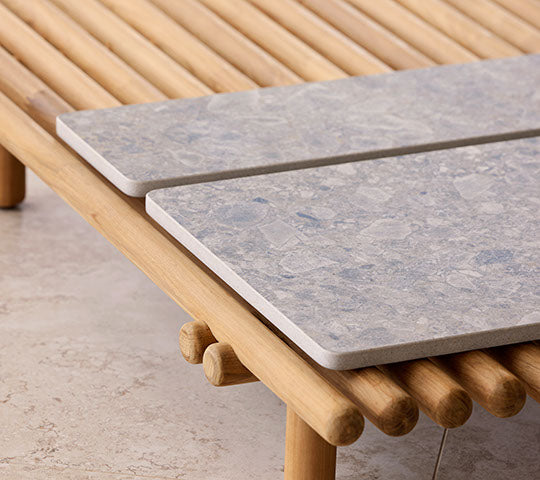 En treplattform har to steinbordplater som fremhever et moderne design med naturlige elementer for en stilfull presentasjon.