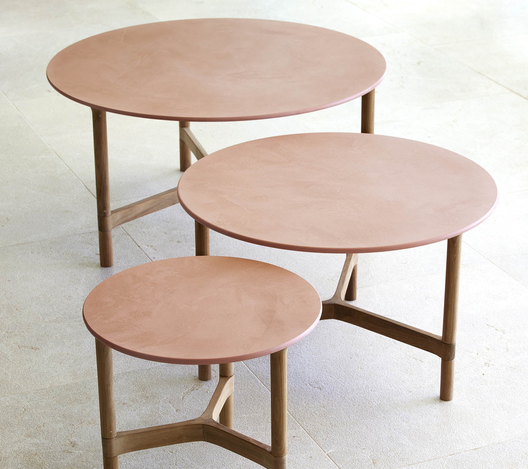 Tre runde salongbord i ulike størrelser, med et minimalistisk design, treben og en glatt, elegant overflate.