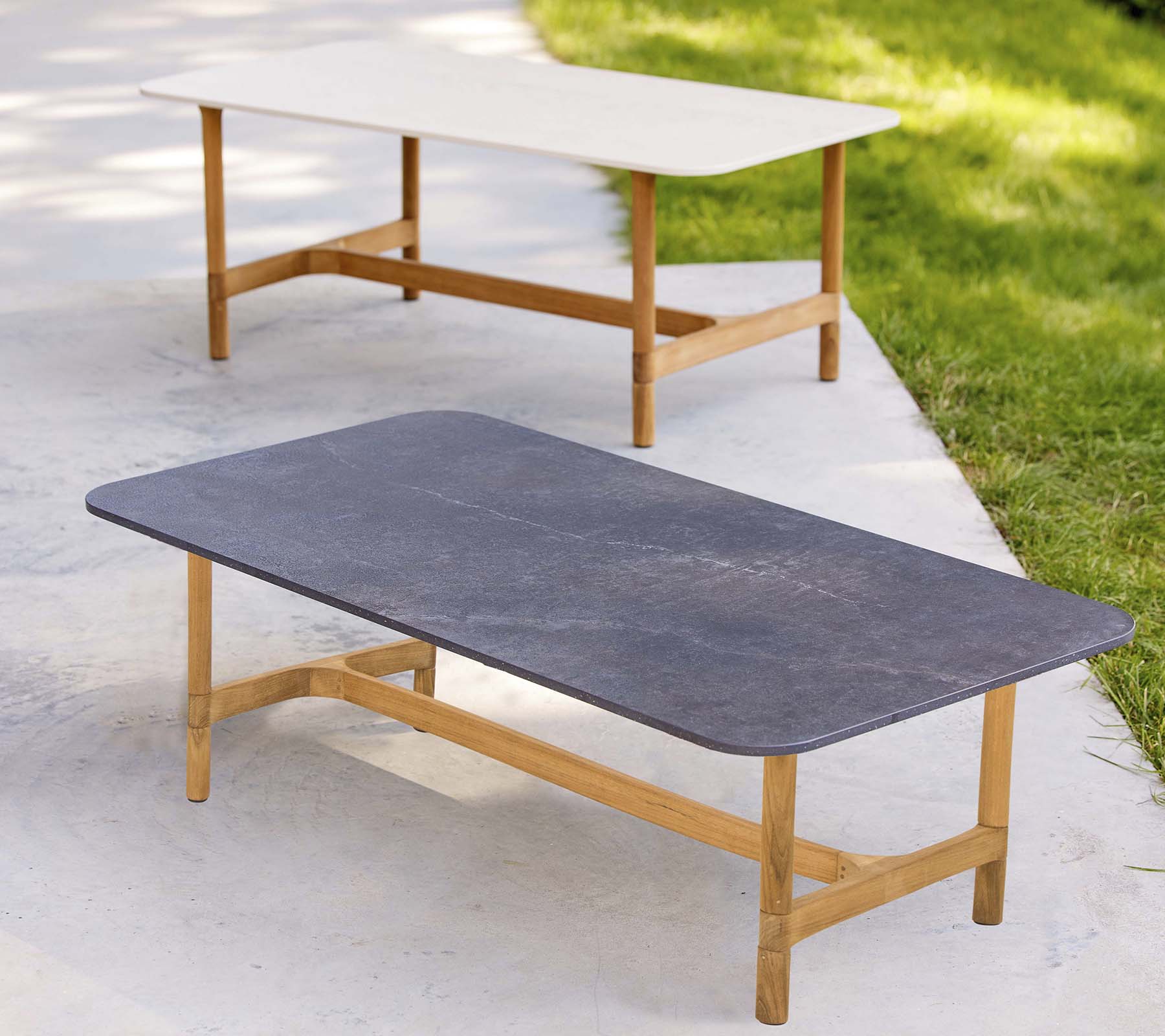 To stilige kaffebord med trerammer og kontrasterende bordplaterfarger, med et moderne, minimalistisk design.