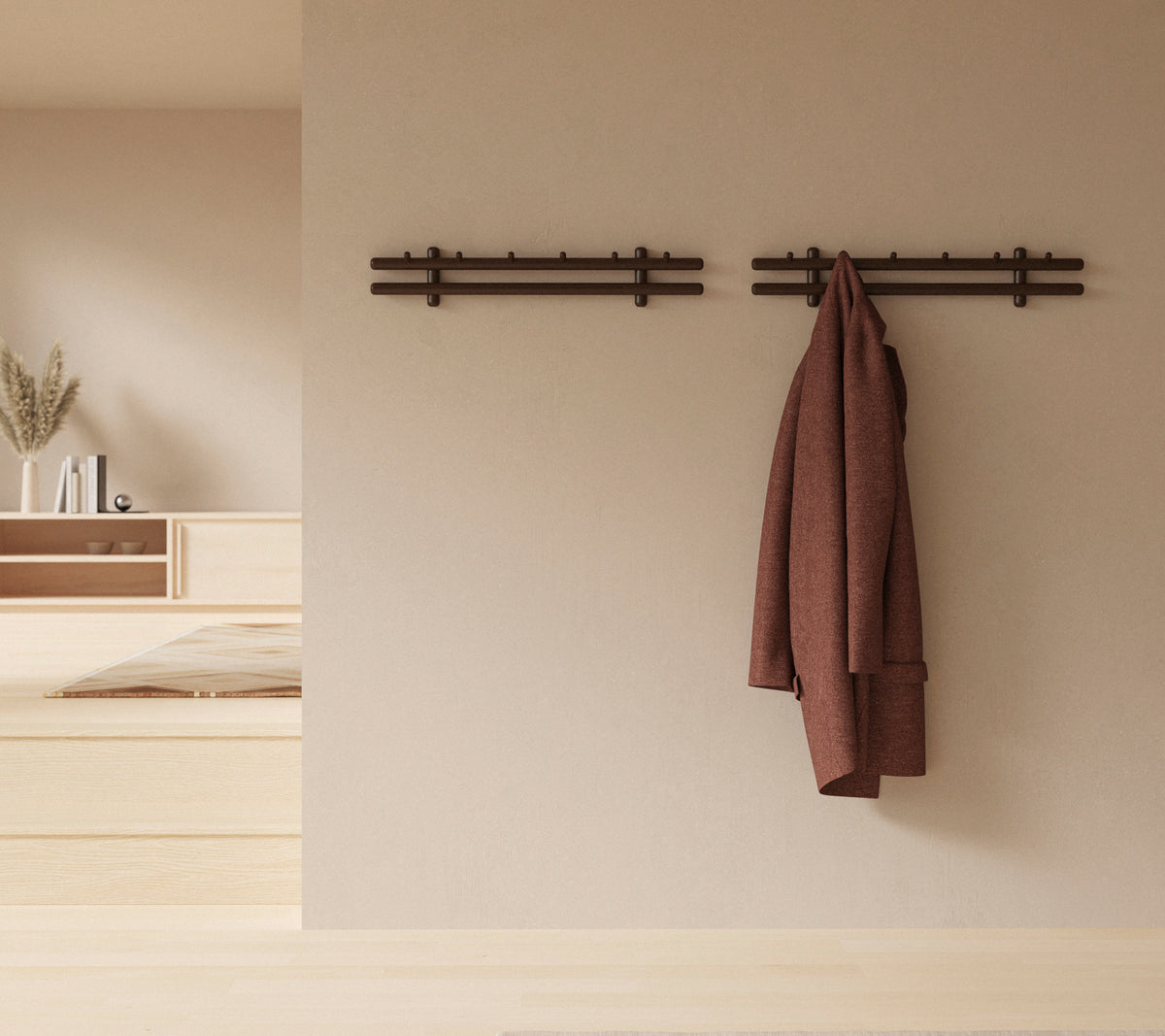 En minimalistik veggdisplay med trestenger som holder en frakk og en samling kluter, som forbedrer den rustikke dekorativestetik.